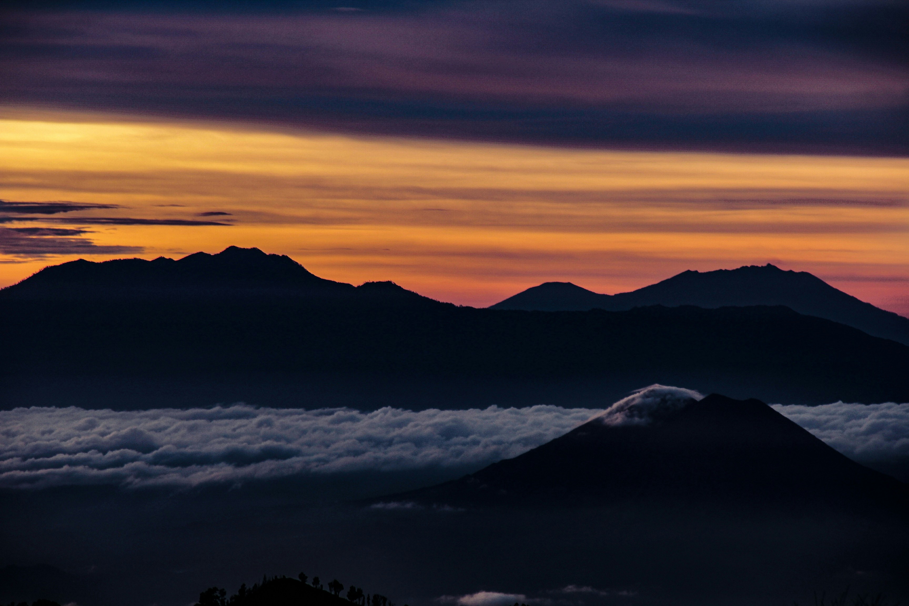 Silhouetted Peaks Over Sea of Clouds