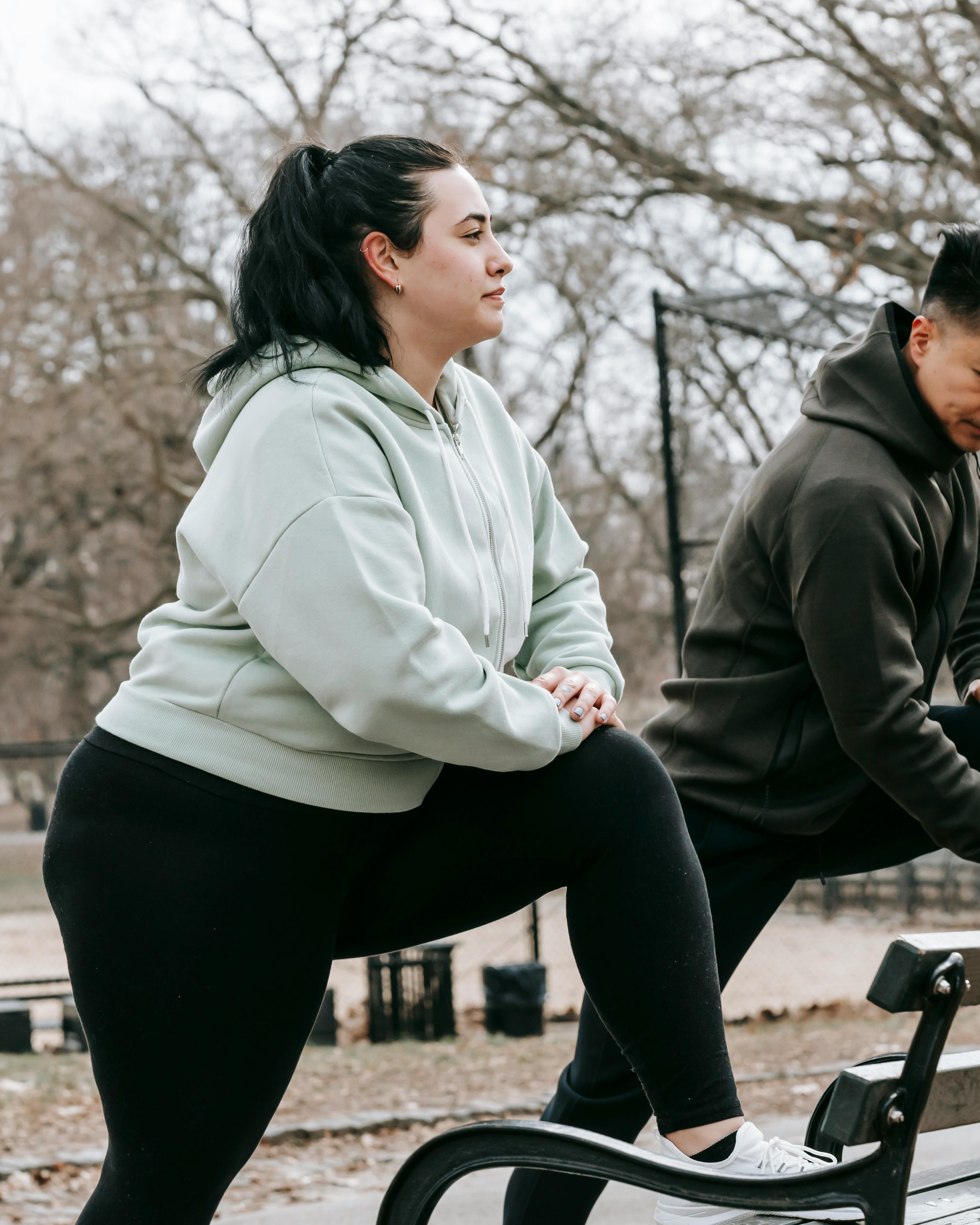 Two People Stretching Outdoors in Park