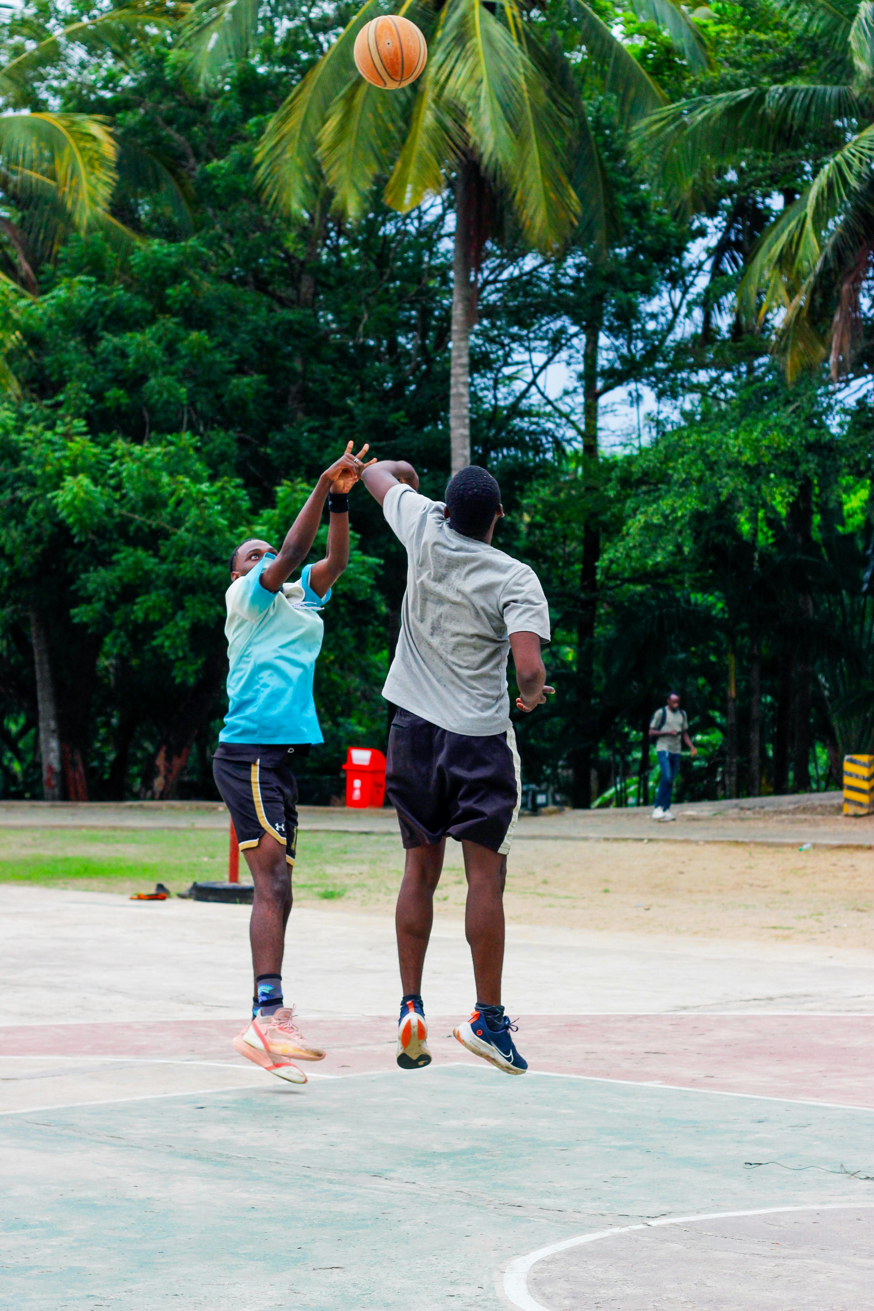 Two Men Playing Basketball Outdoors