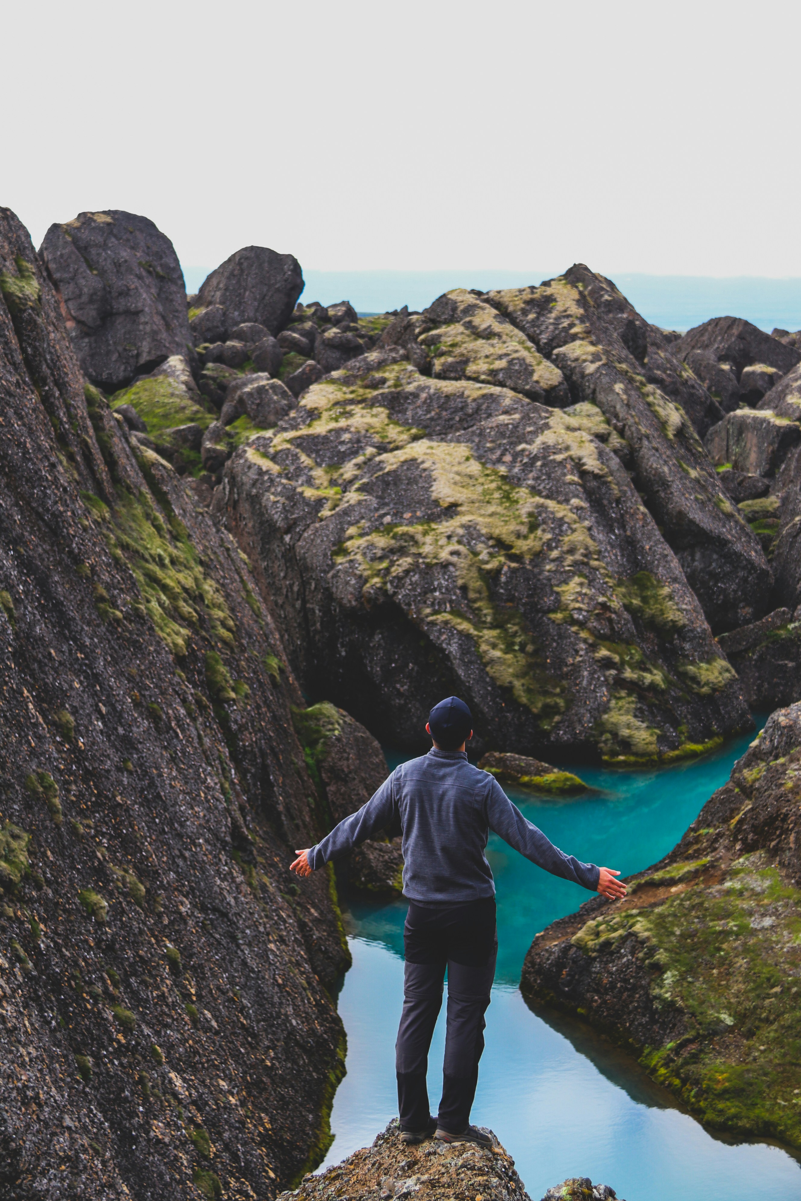 Hiker Overlooking Turquoise Mountain River