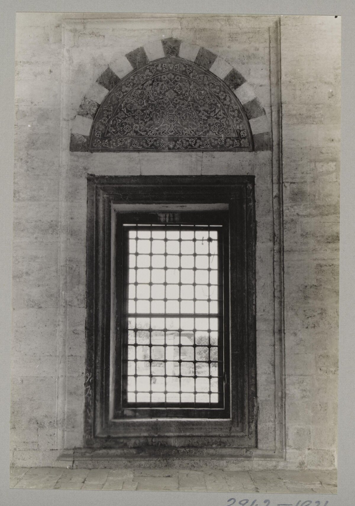 Ornate Arched Window on Stone Wall