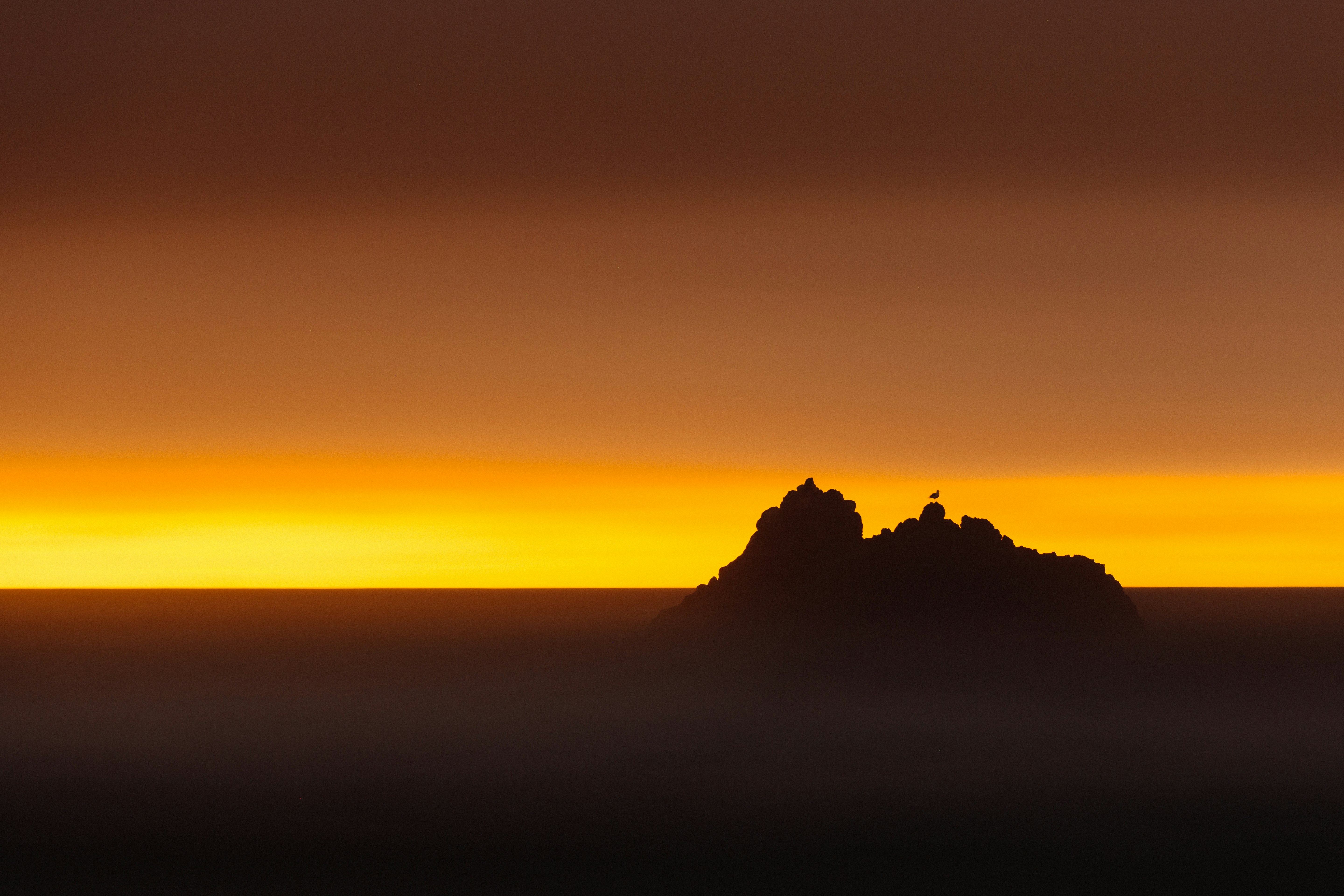 Rock Silhouette Above Cloud Sea at Sunset