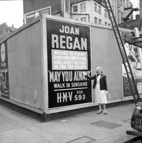 Joan Regan Poses By Her Billboard Ad