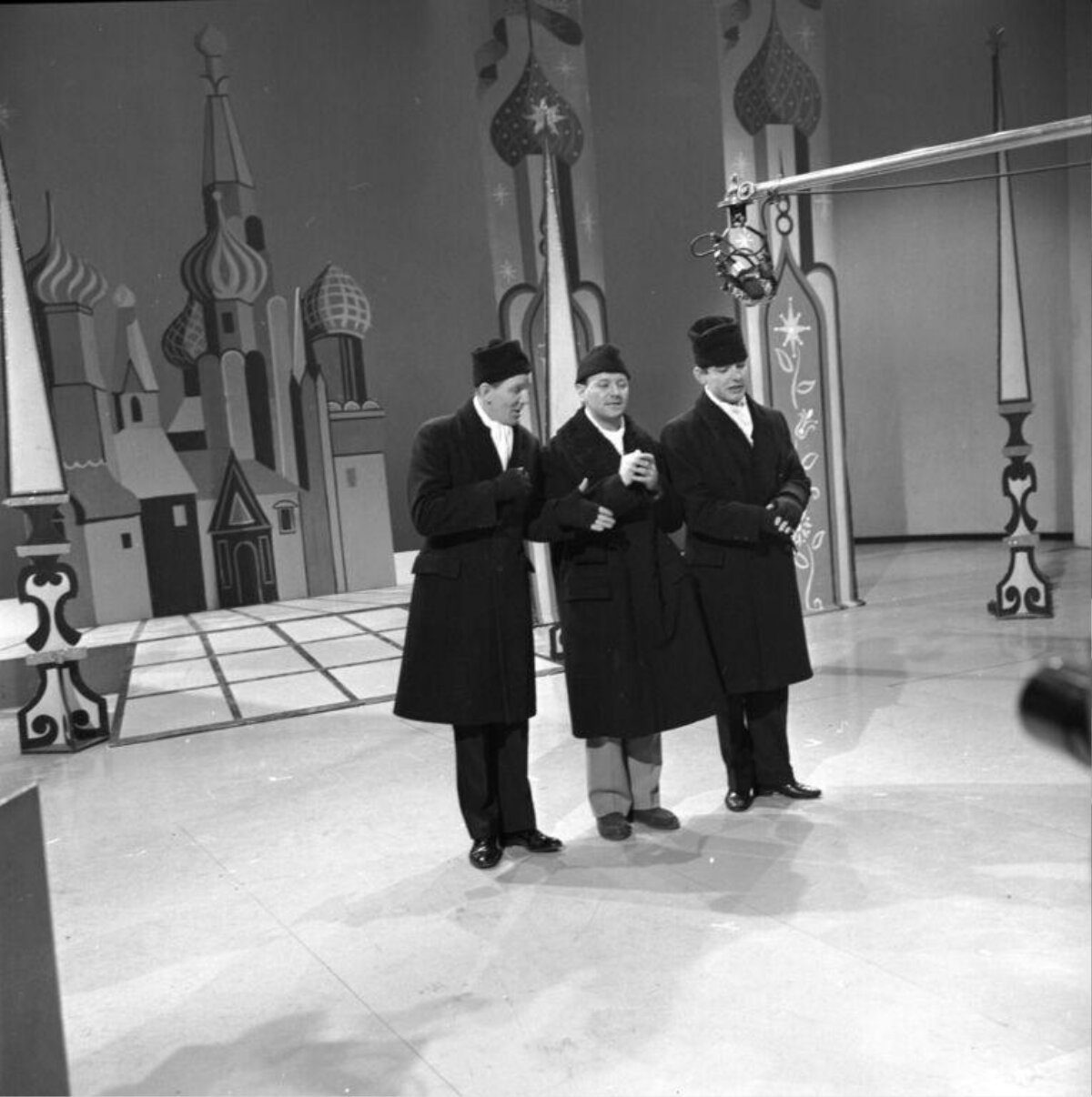 Three Men Performing On Television Stage