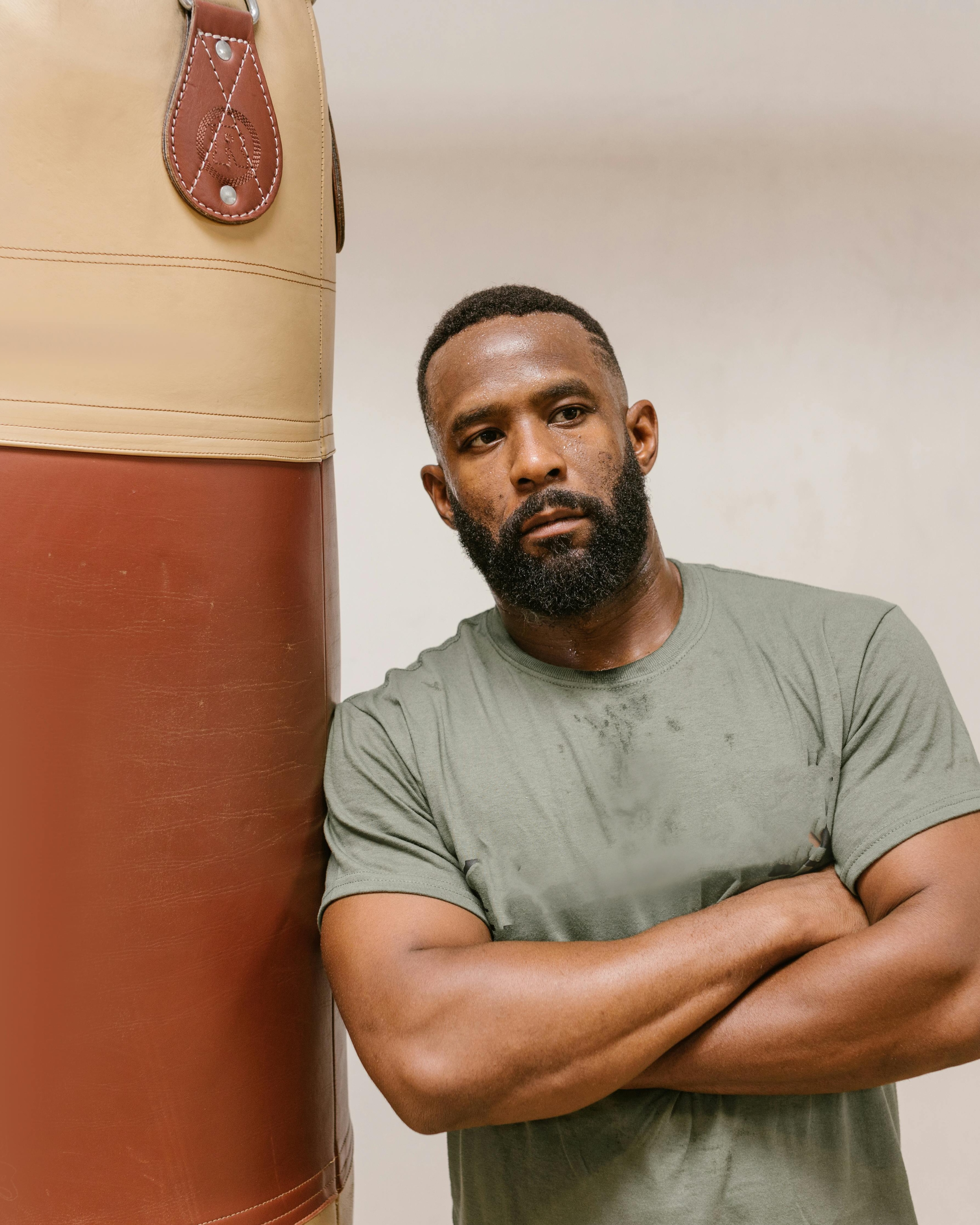 Black Boxer Leaning Against Punching Bag