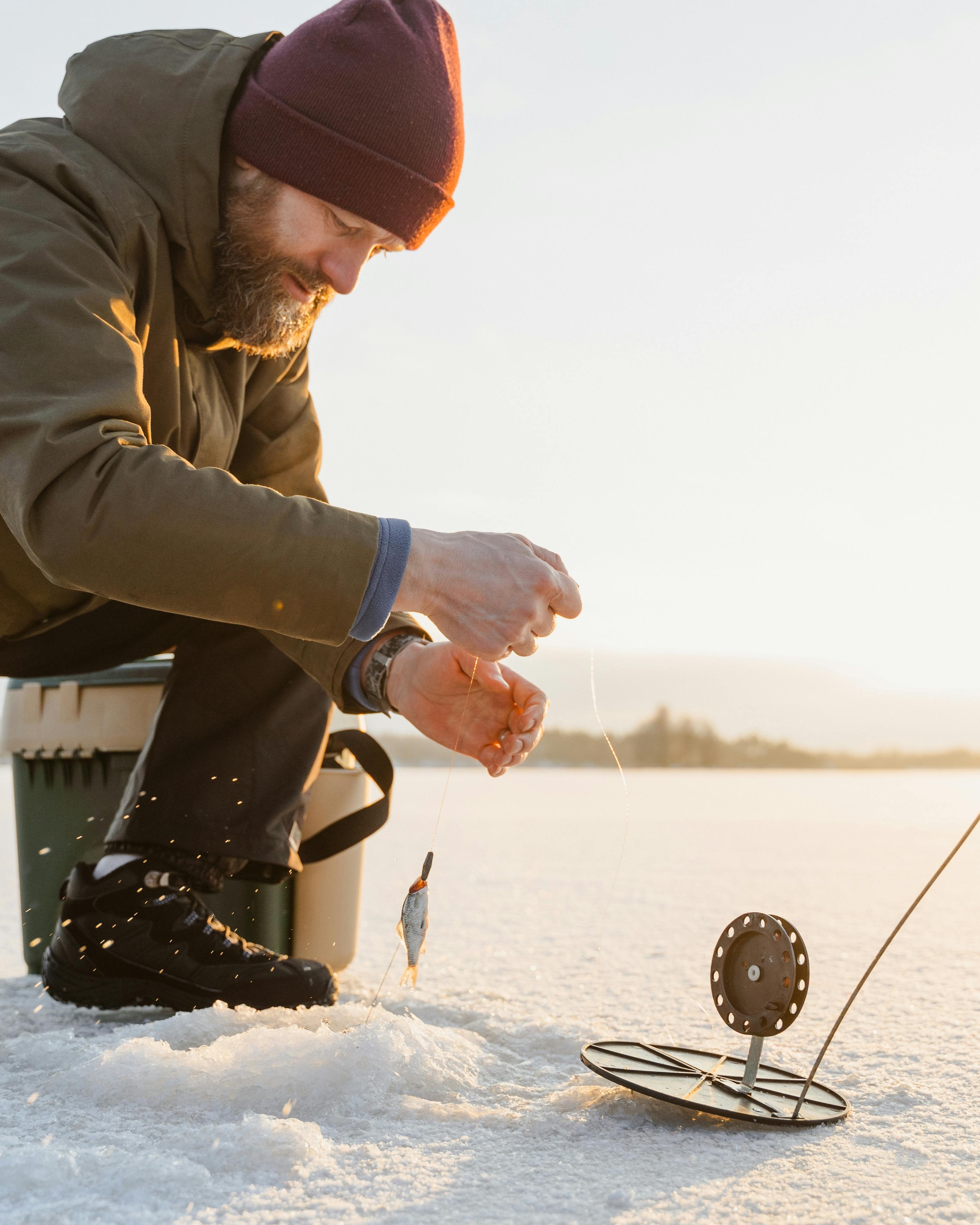Man Ice Fishing on Frozen Lake