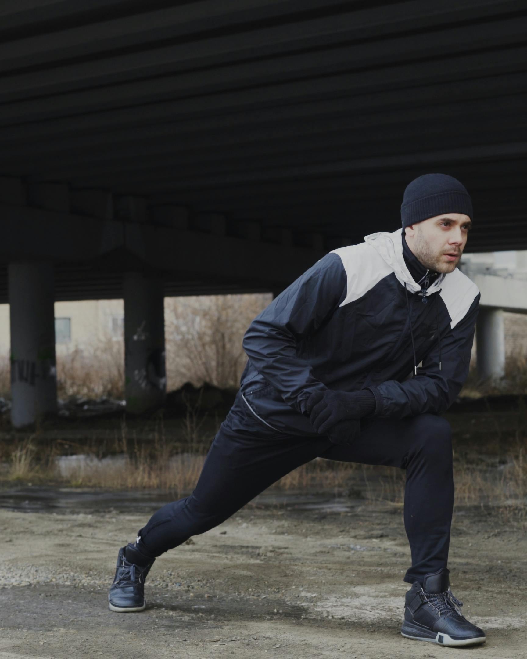 Man Stretching for Exercise Under Overpass