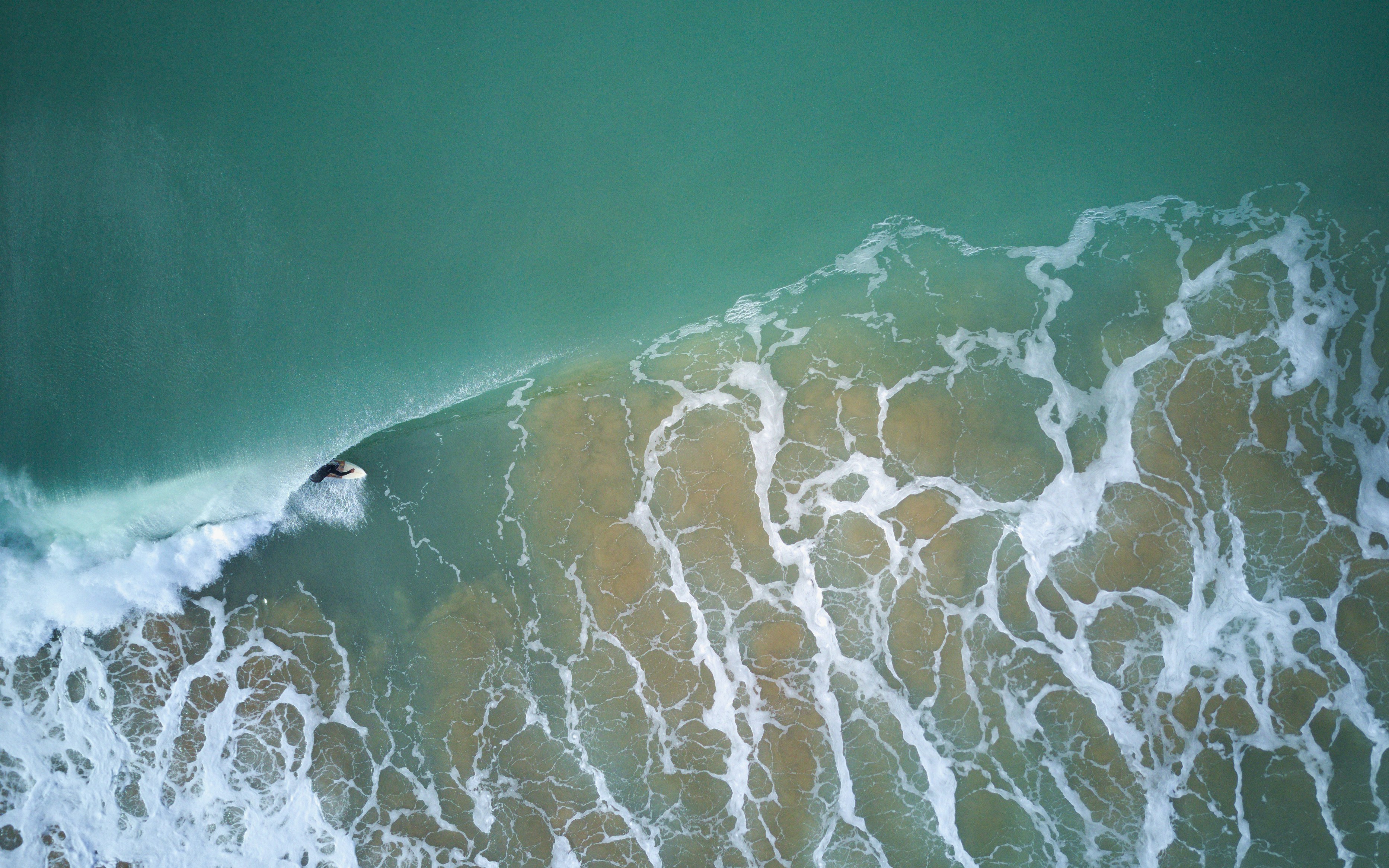 Aerial View of Surfer Riding Wave