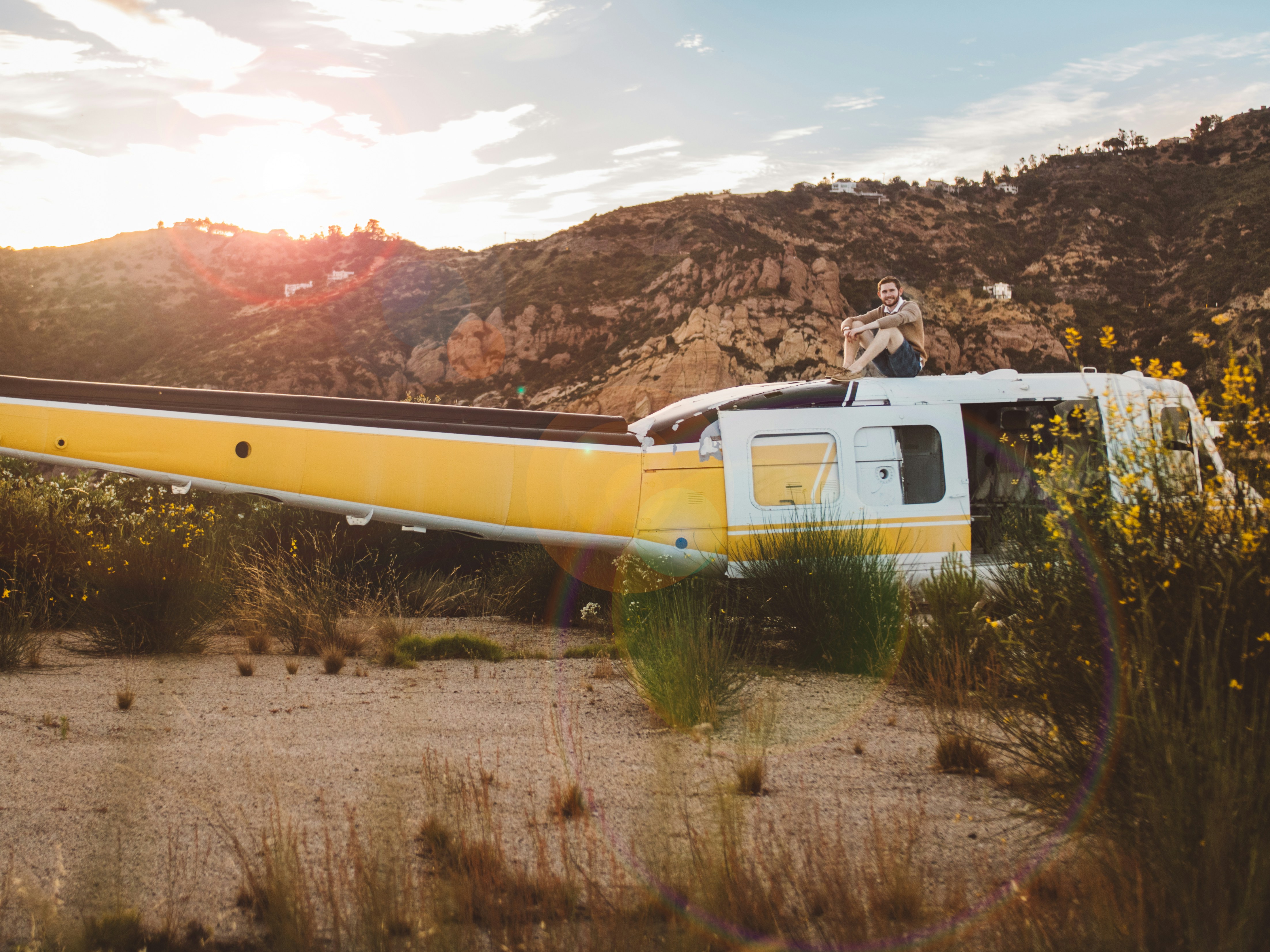Man Sitting on Helicopter at Sunset