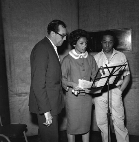 Three Musicians Reviewing Sheet Music