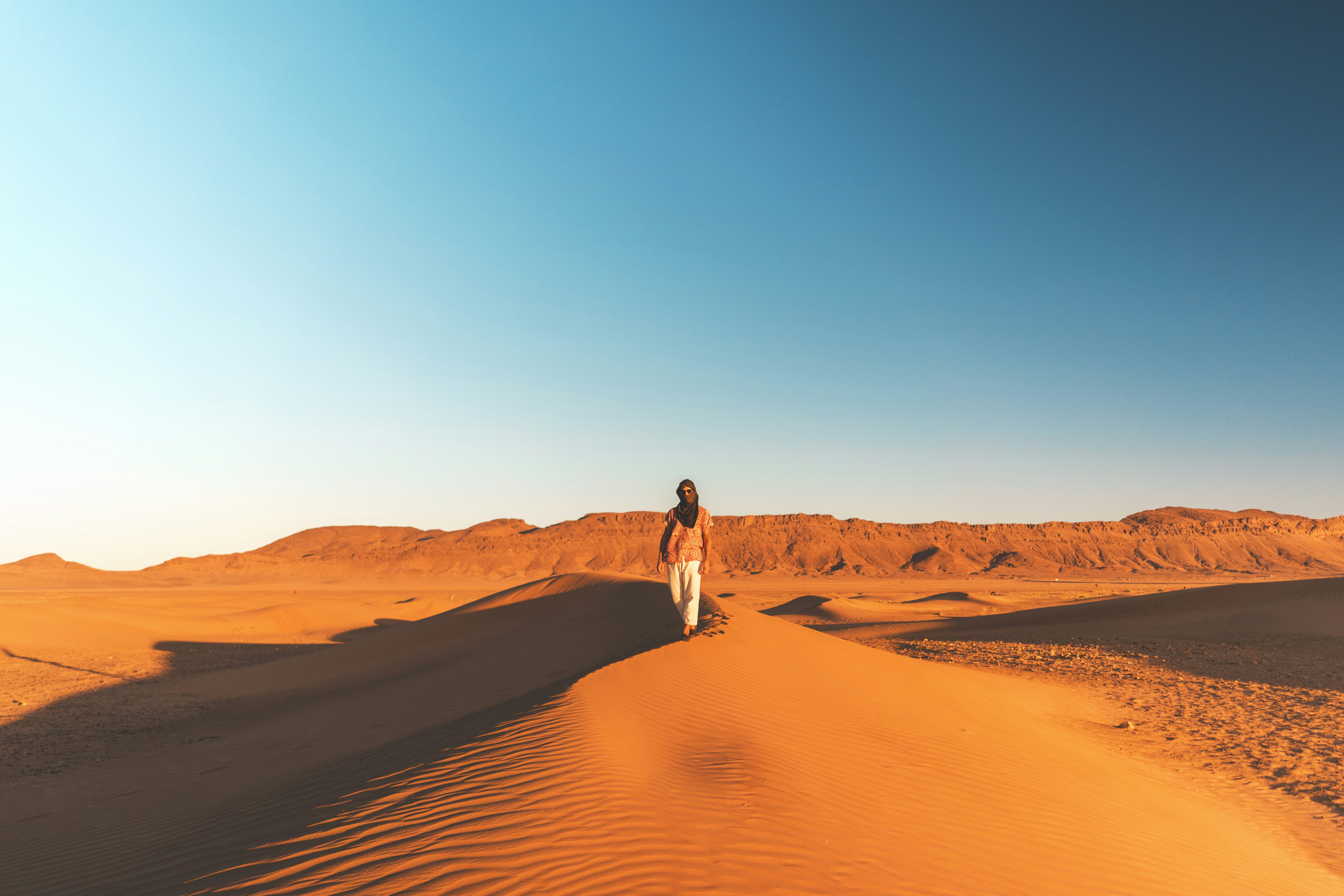 Traveler Walking on Desert Dune