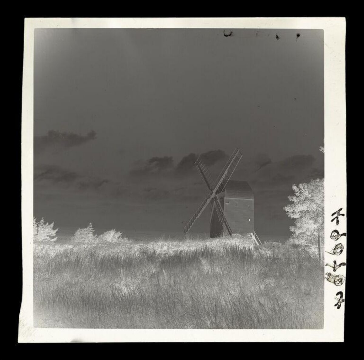 Old Windmill in Grassy Field