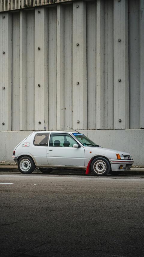 White Classic Hatchback Parked By Concrete Wall