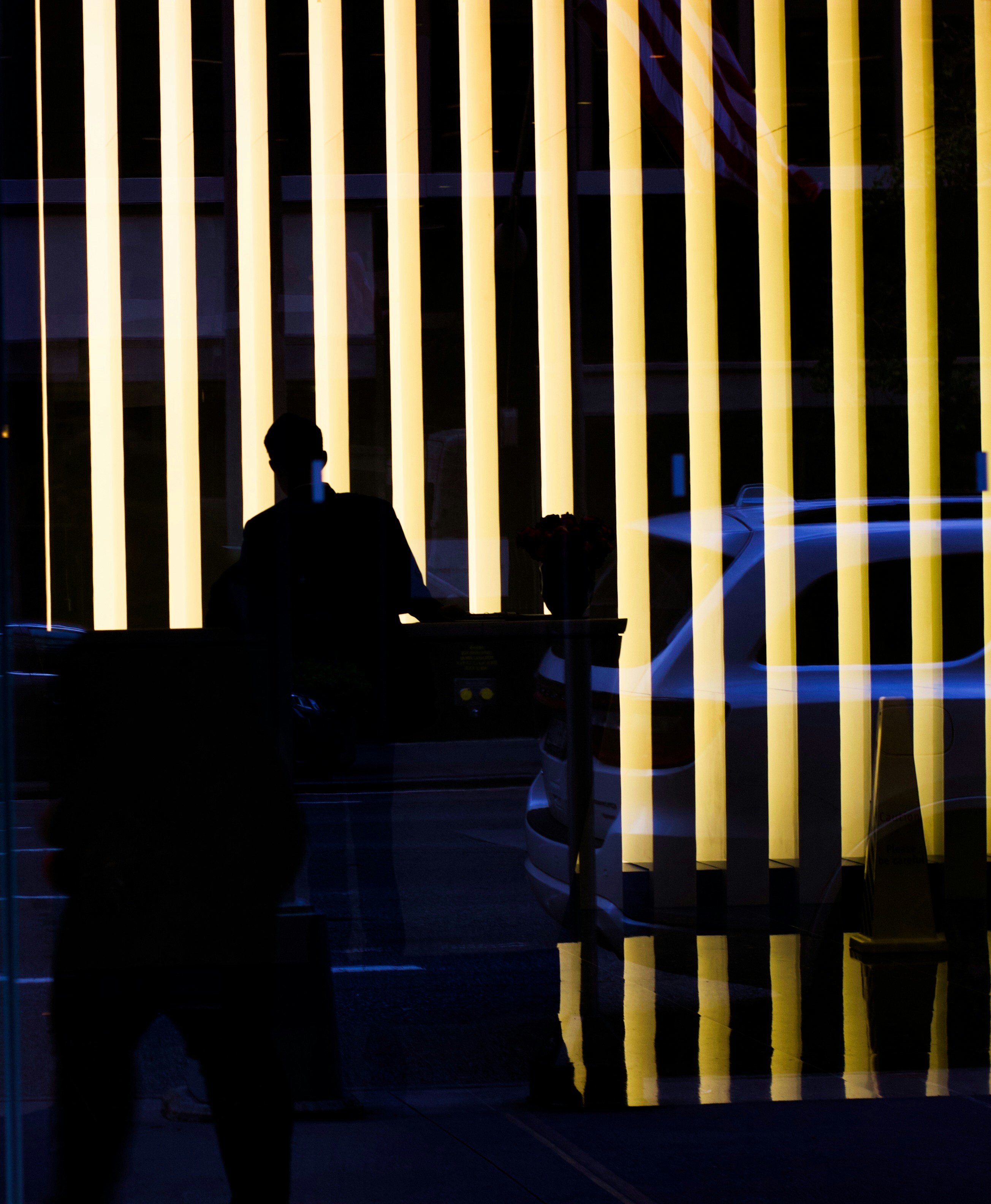 Silhouettes Behind Yellow Vertical Light Strips
