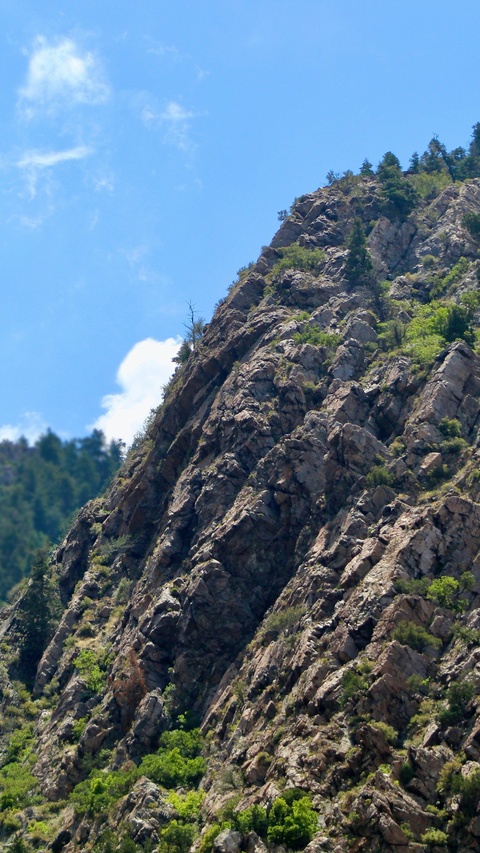 Steep Rocky Cliff Under Blue Sky