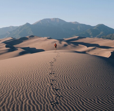 Lone Hiker on Desert Sand Dunes