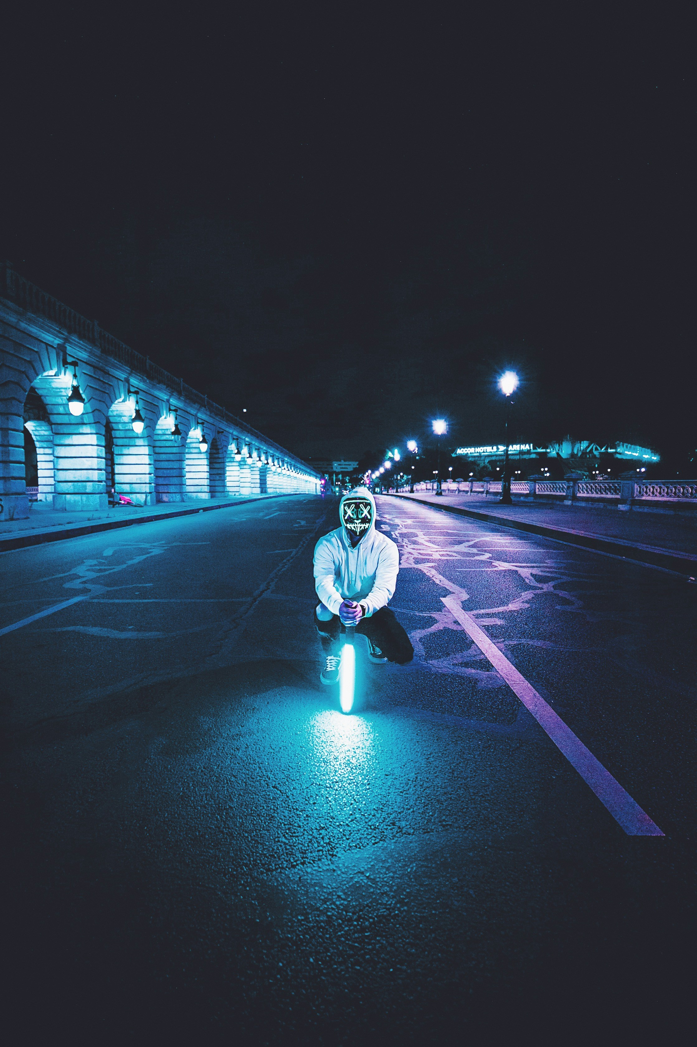 Neon Masked Figure on Night Bridge