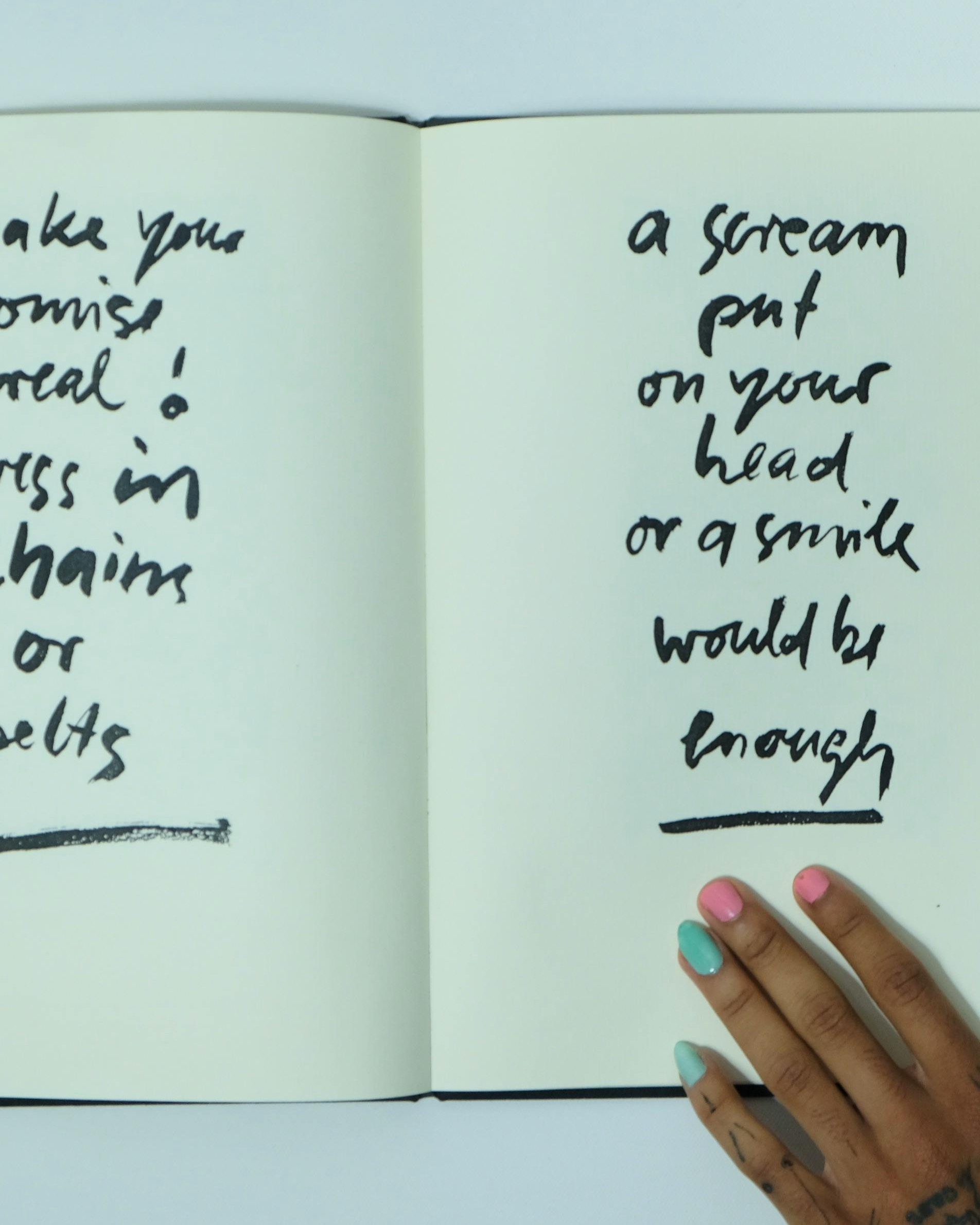 Handwritten Quote in Open Notebook With Manicured Hand
