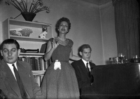 Woman Singing Beside Grand Piano