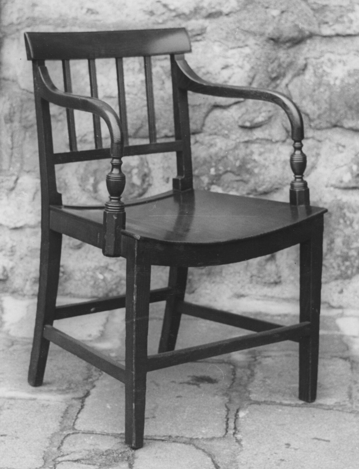 Dark Wooden Armchair Against Stone Wall