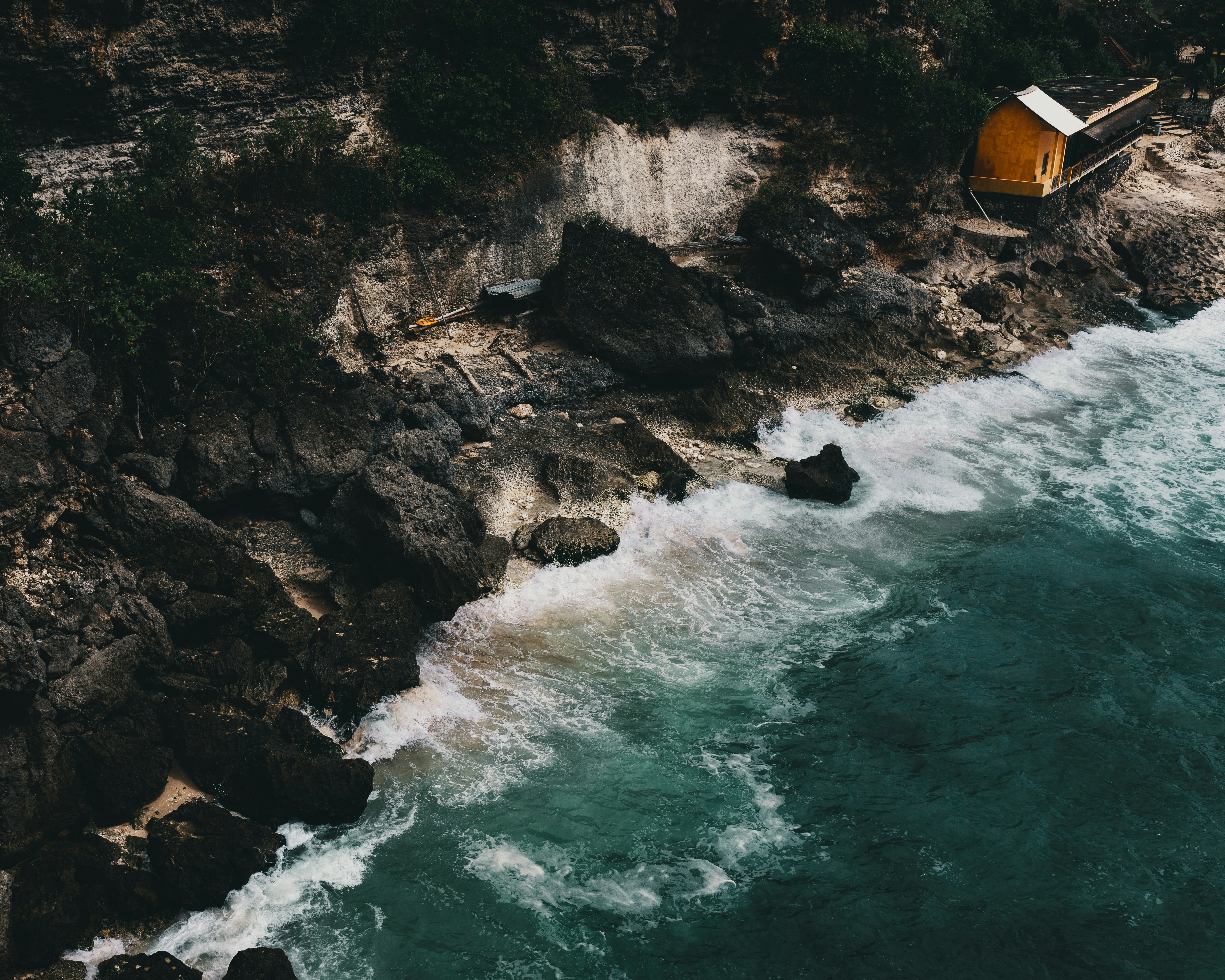 Yellow House on Rocky Coastal Cliff