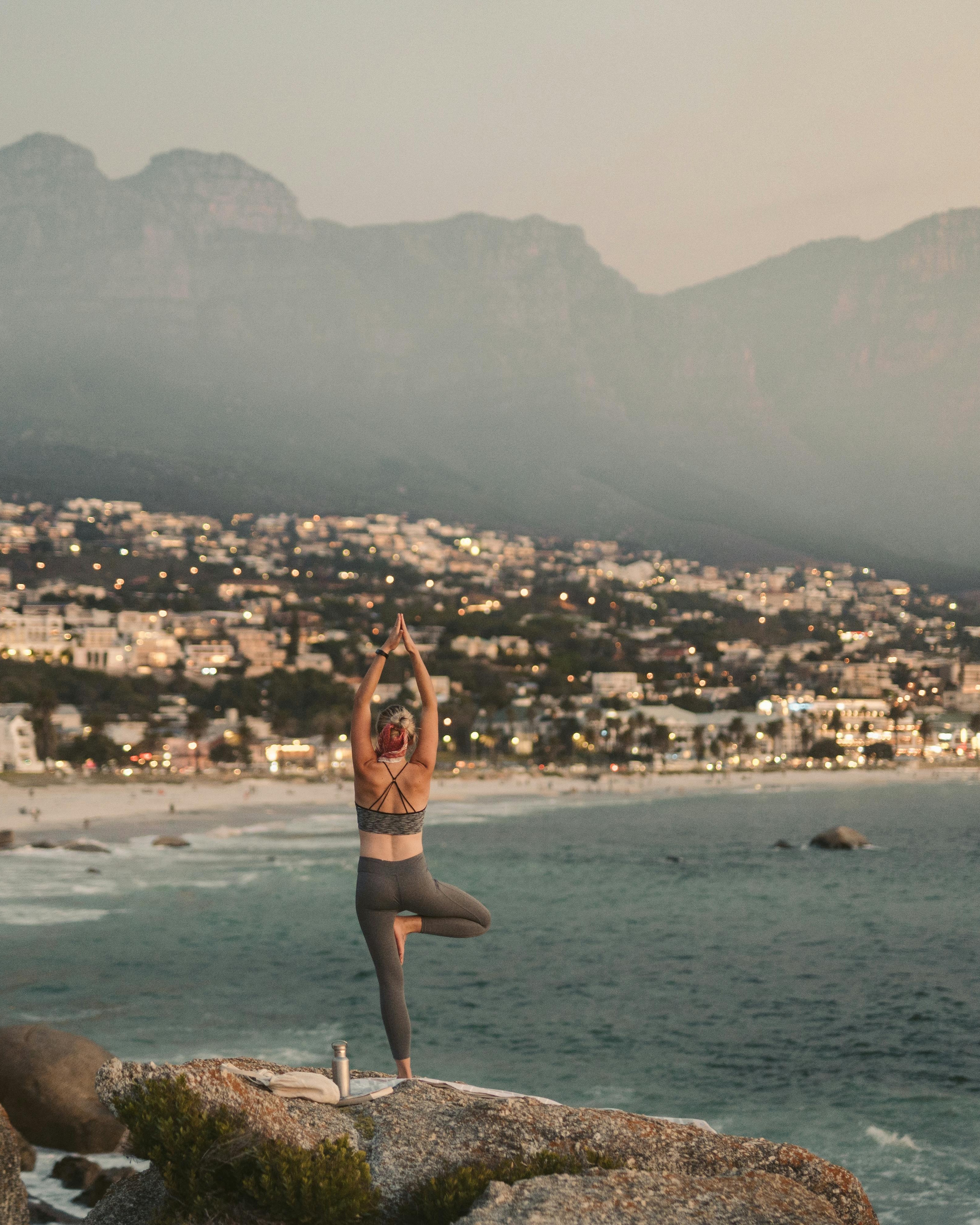 Woman Doing Yoga Overlooking Coastal City