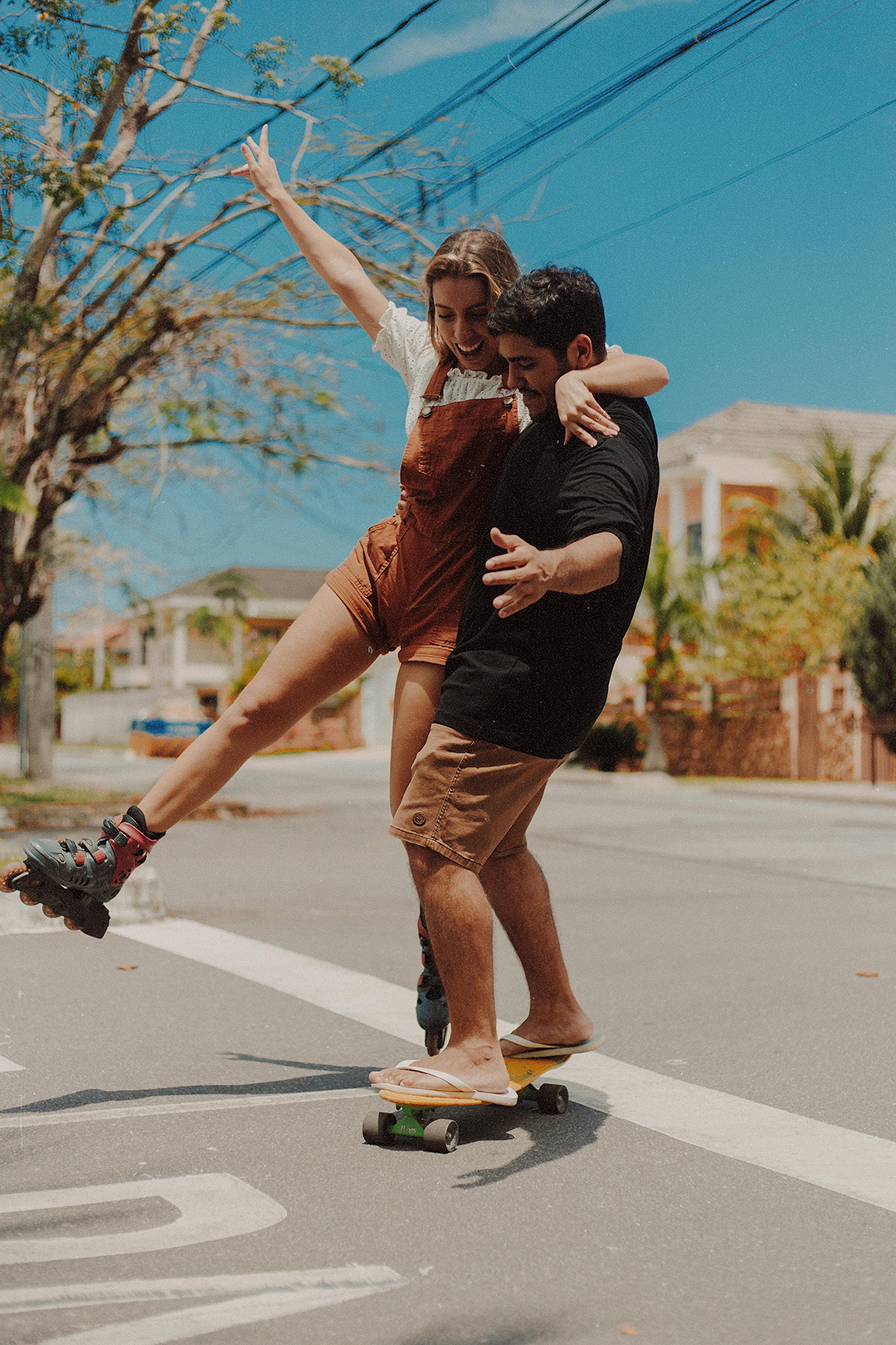 Couple Skateboarding on Suburban Street