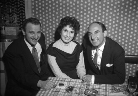Three people smiling at restaurant table