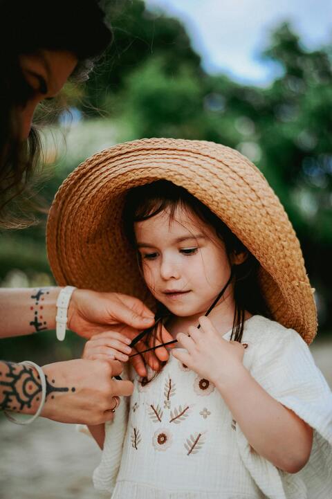 Adjusting straw hat for little girl