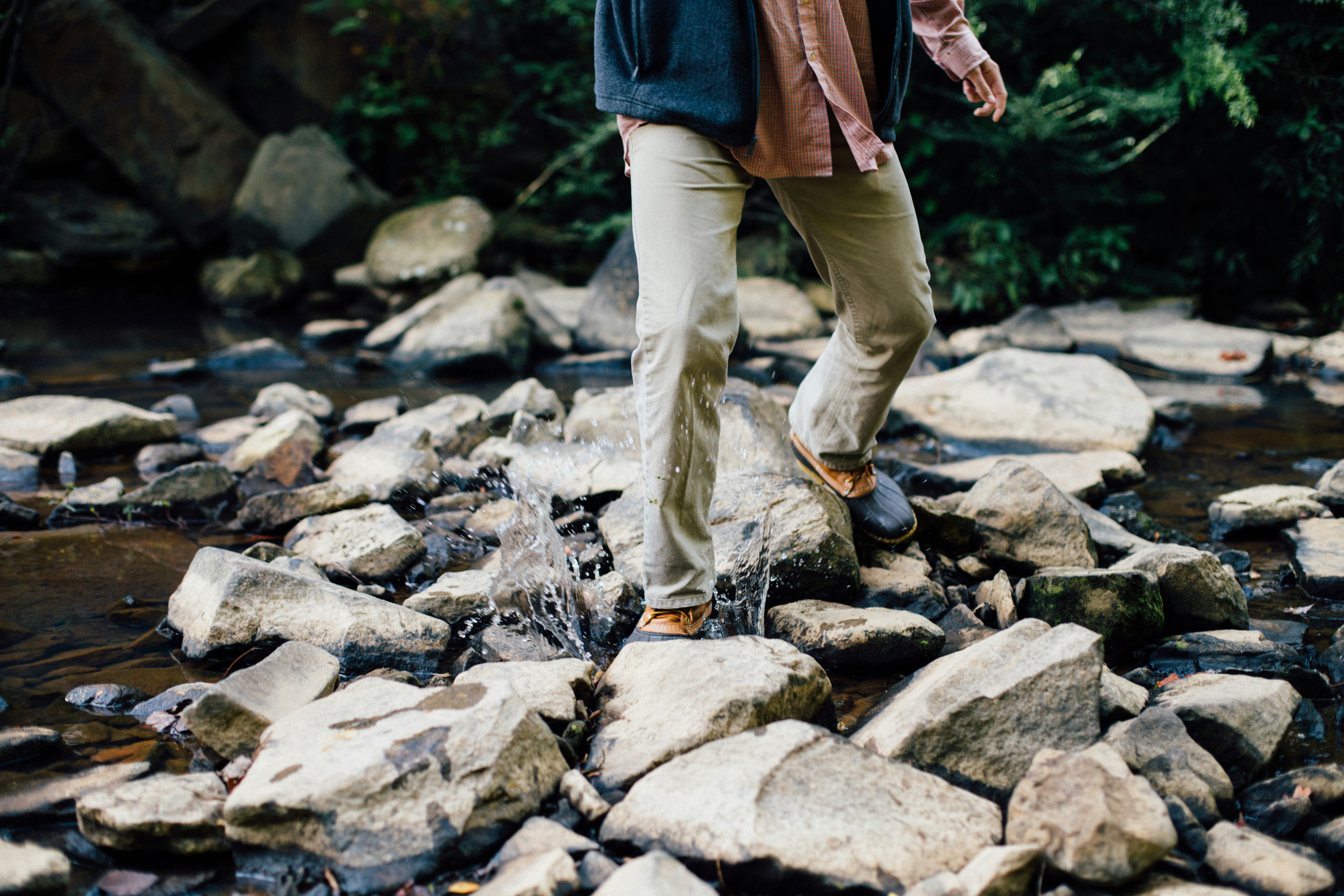Person Crossing Rocky Stream