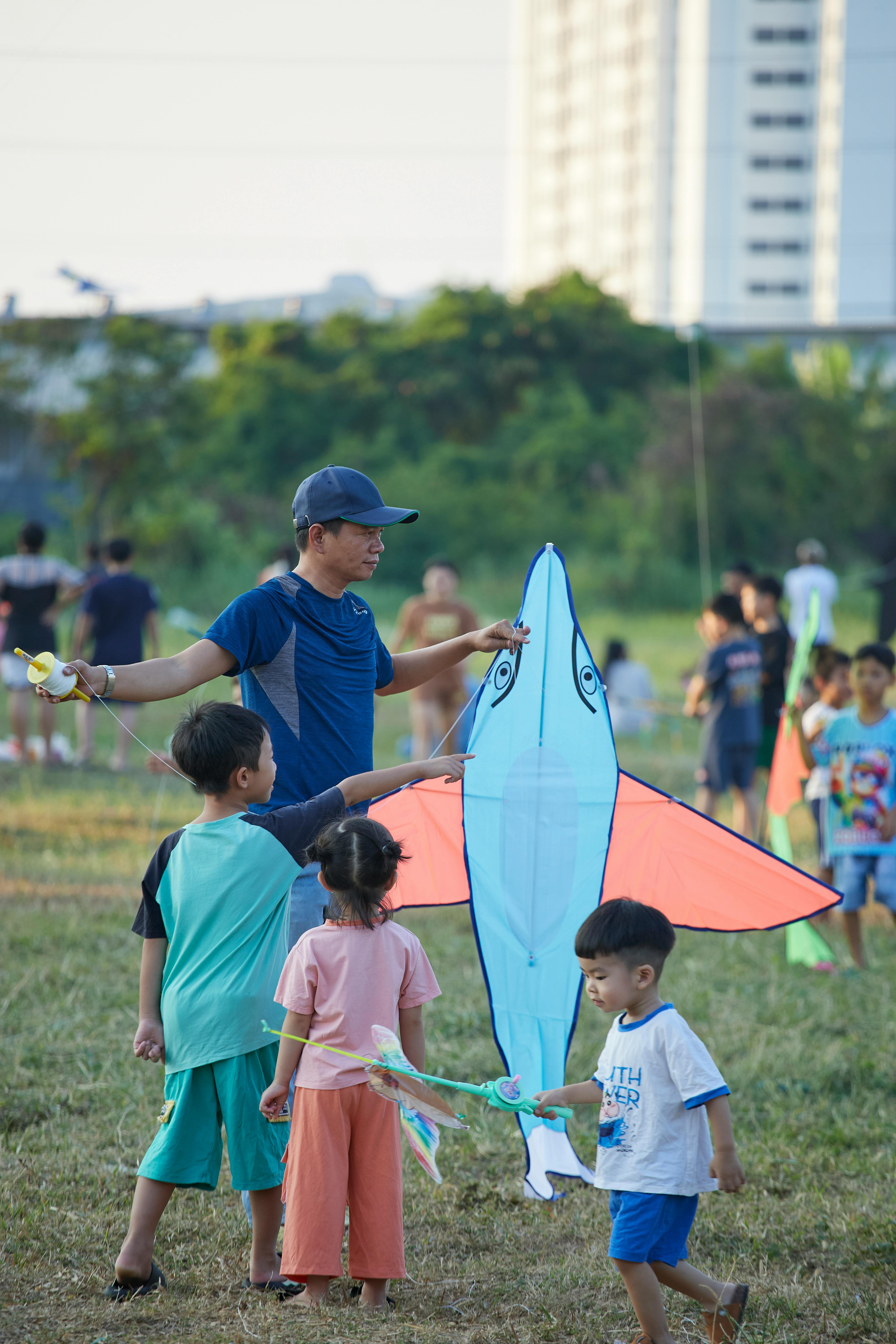 Family Flying Kite on Grass Field