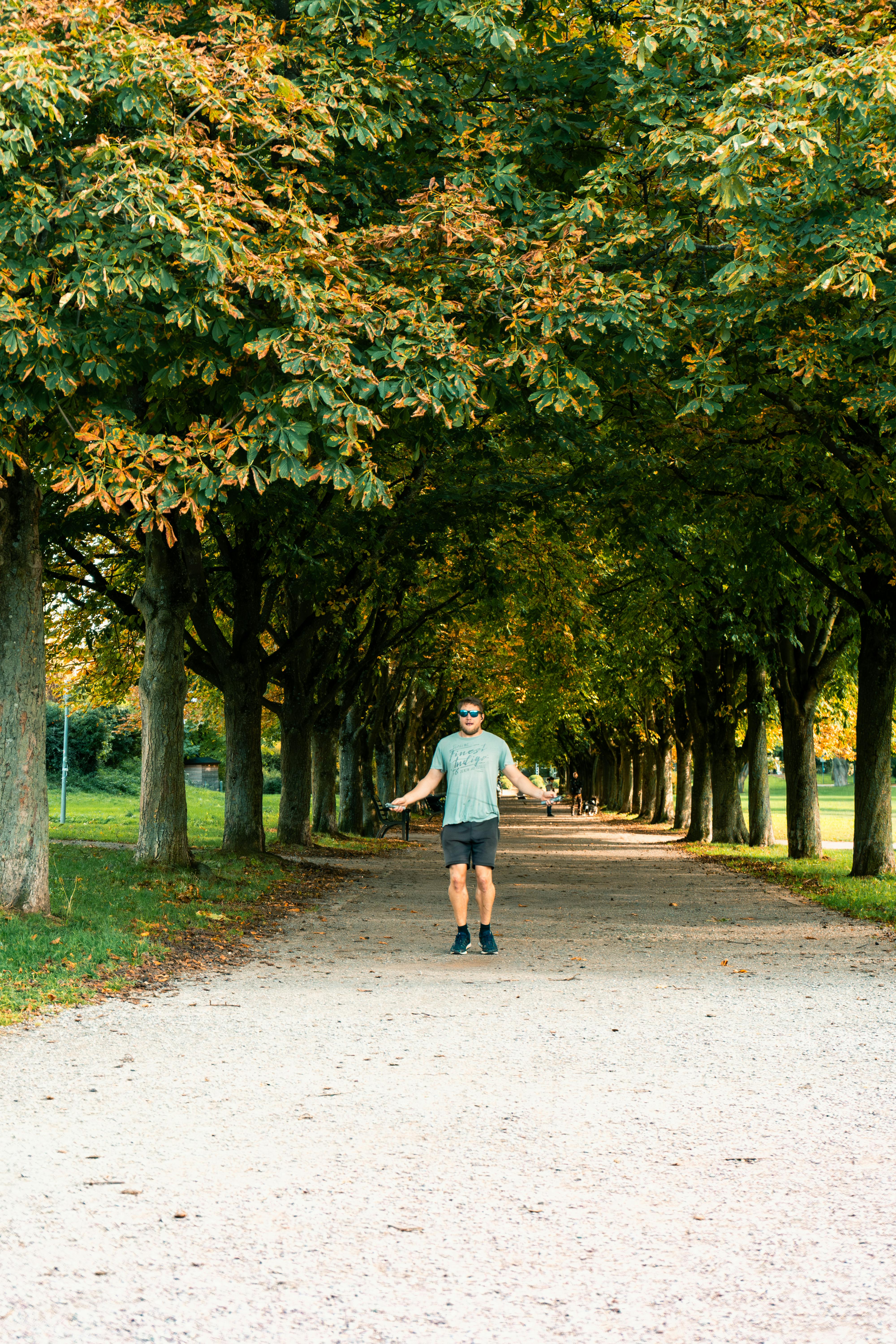 Man Skipping Rope in Tree-Lined Park