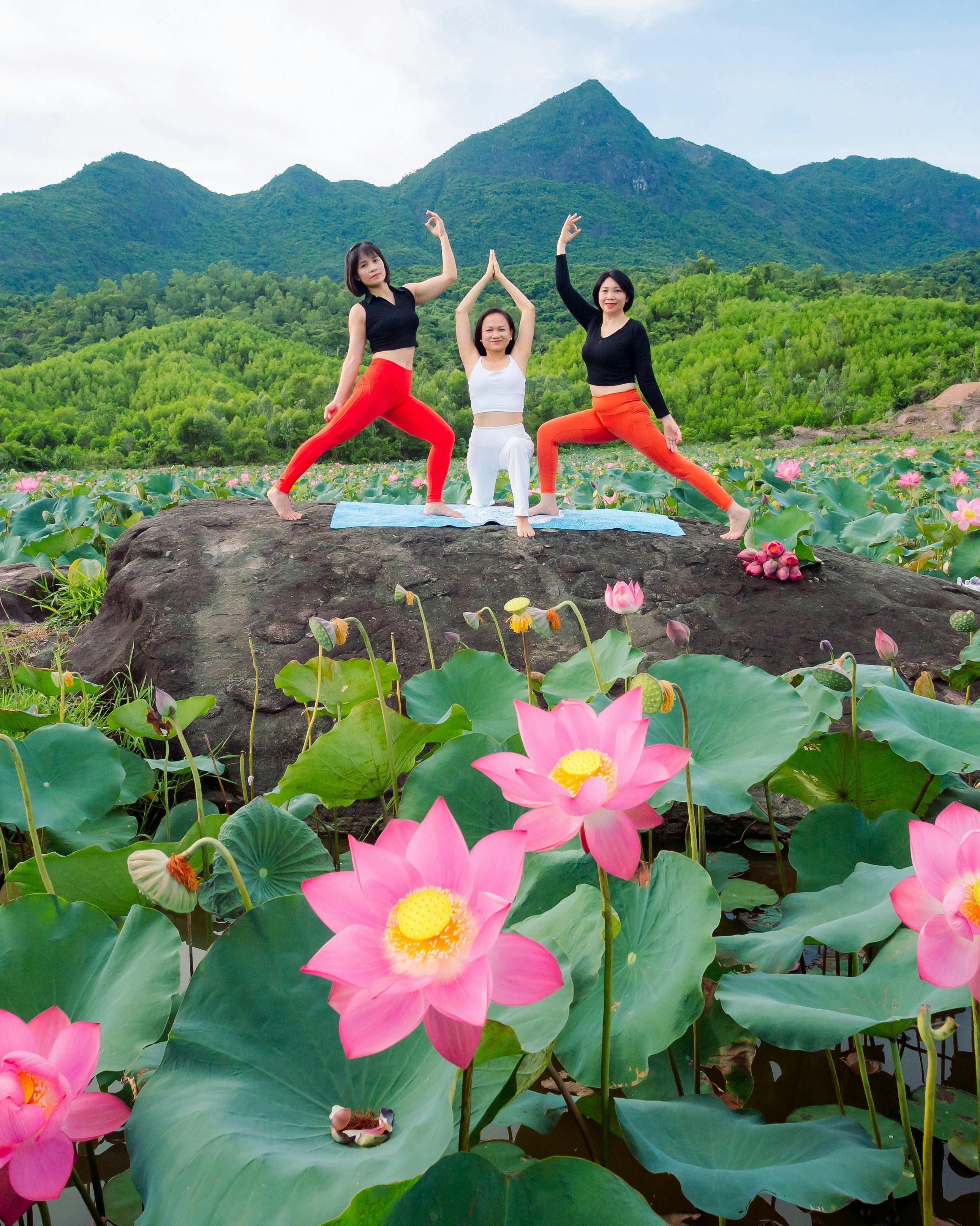 Three Women Doing Yoga in Lotus Field