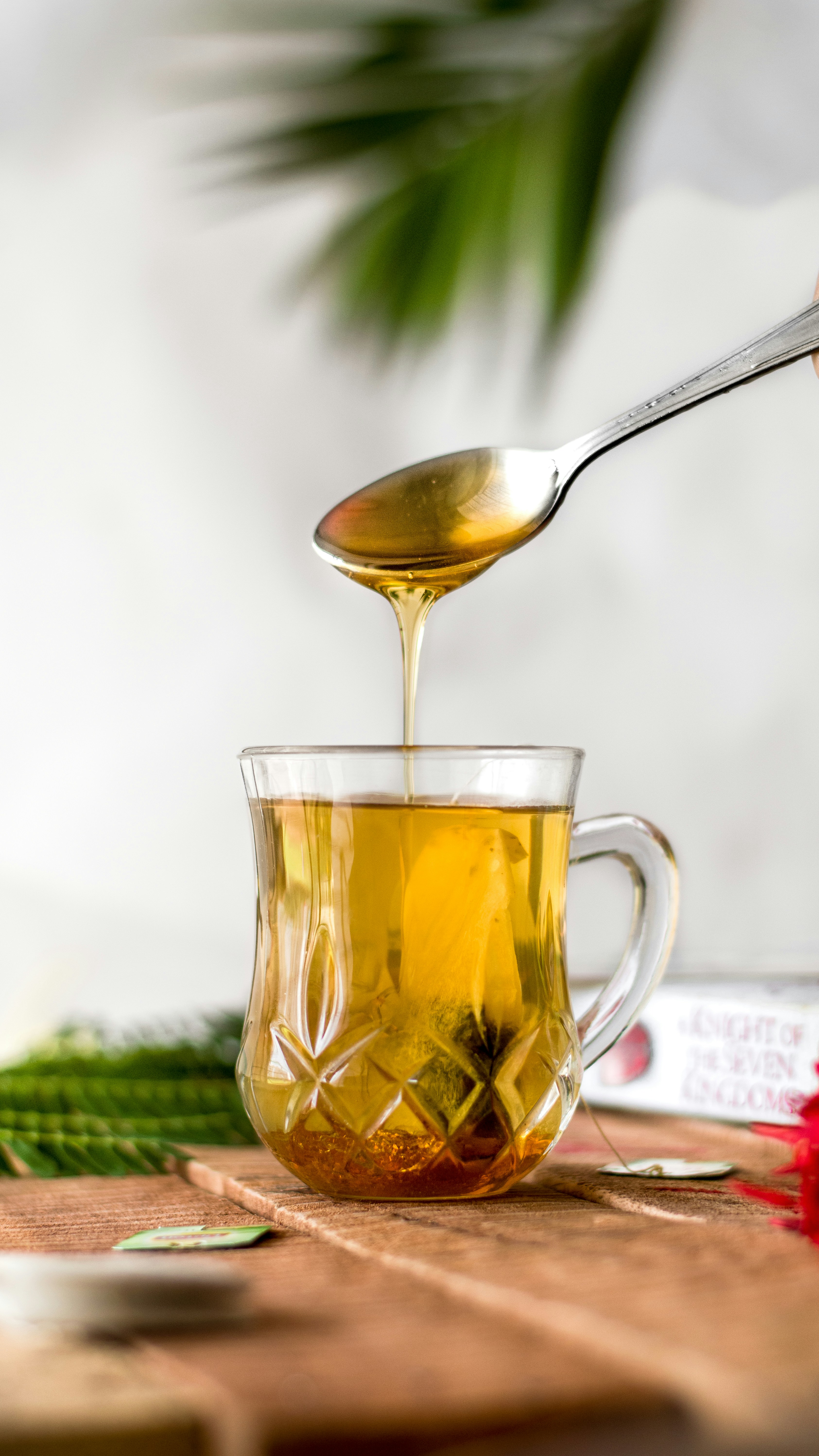 Pouring Honey into a Glass of Tea