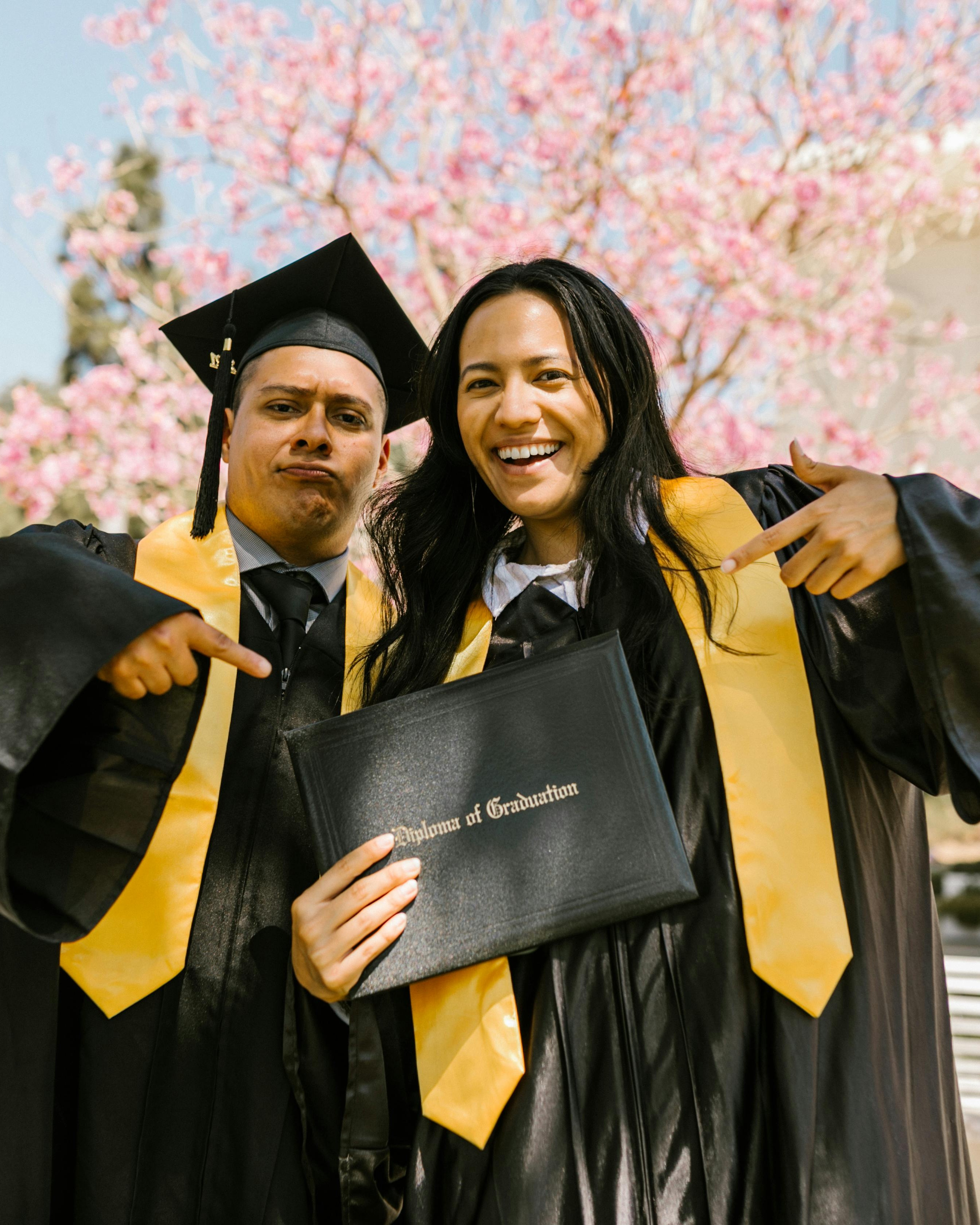 Two Graduates With Graduation Diploma