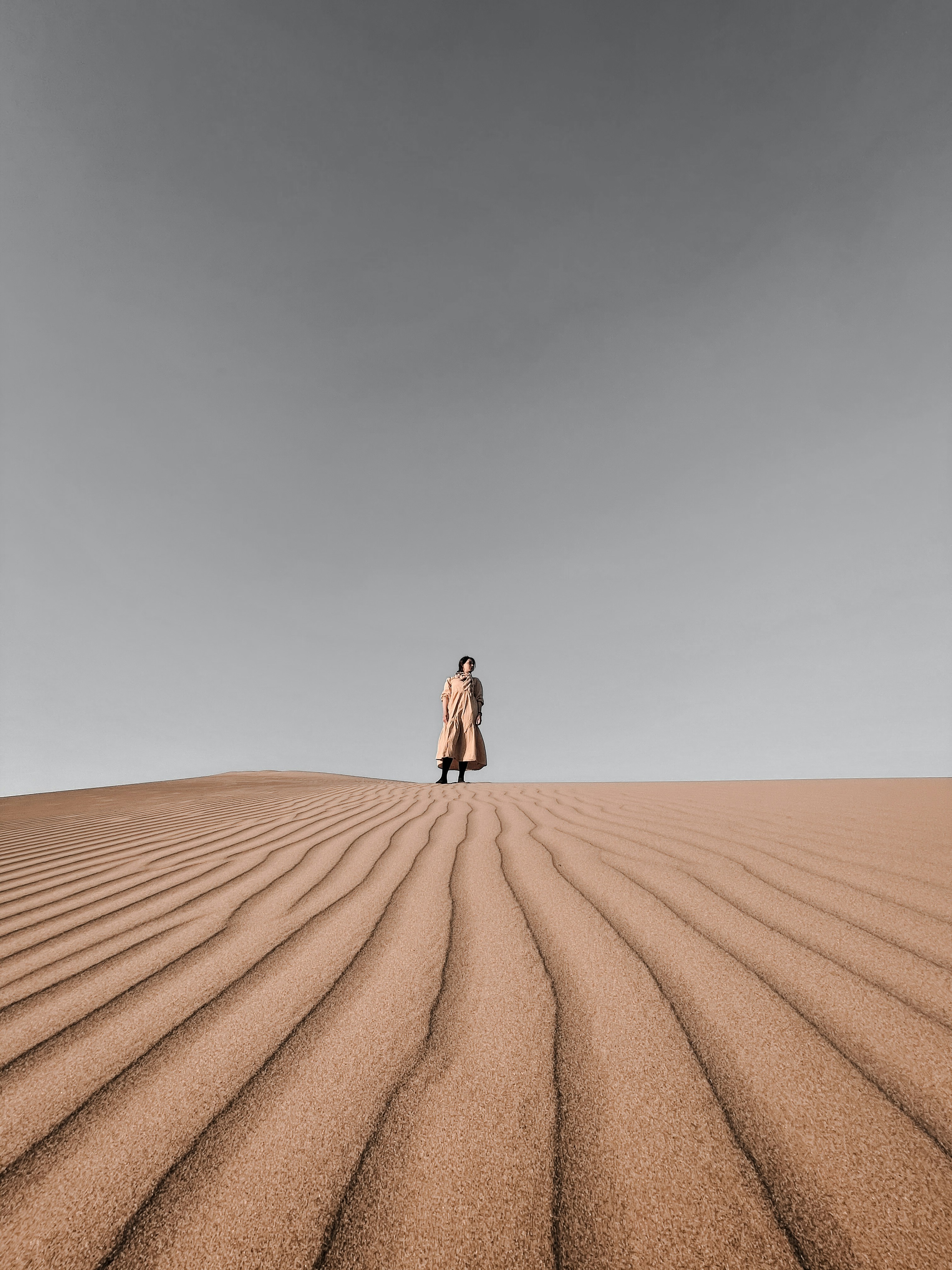 Woman Standing Alone on Desert Dune