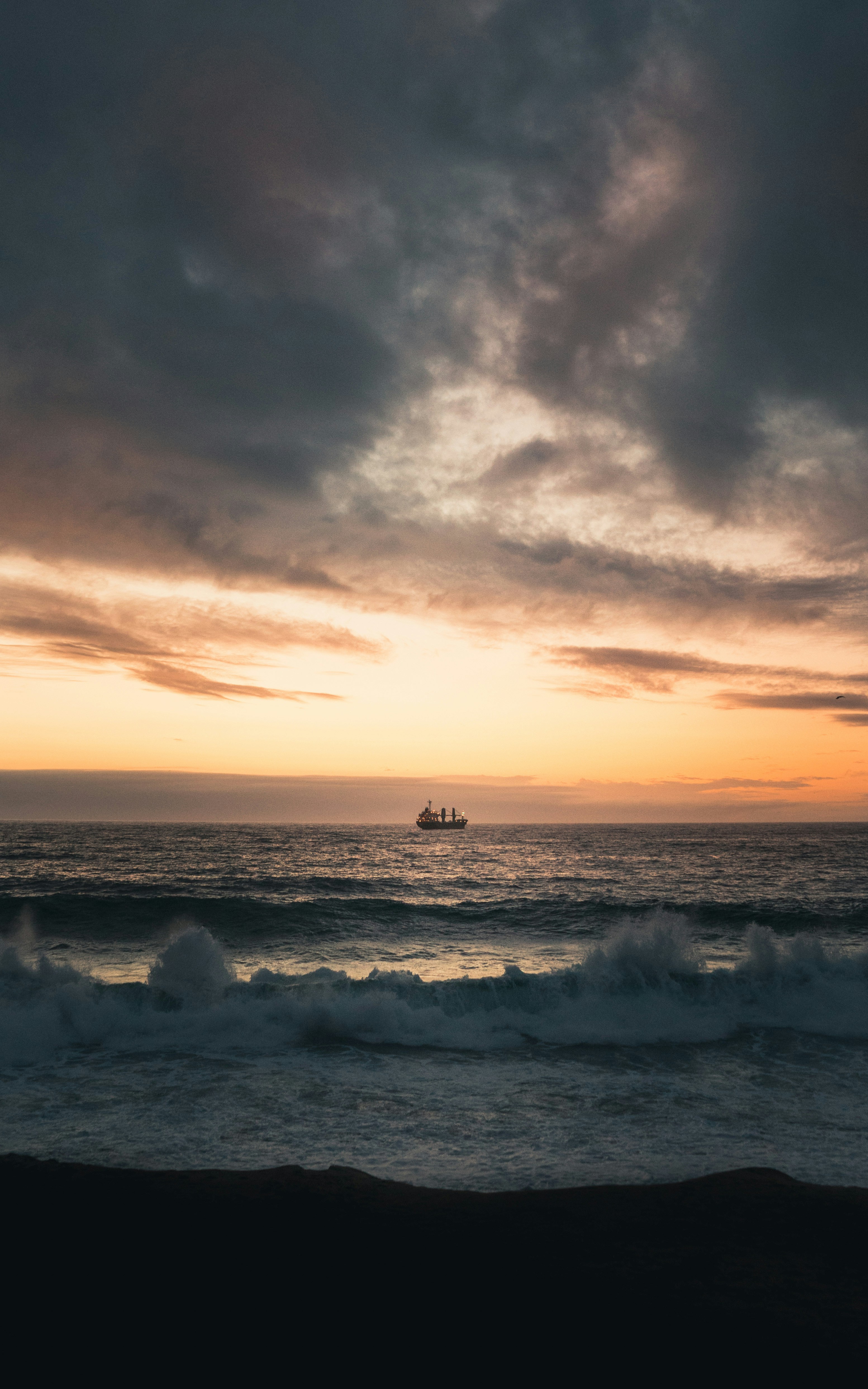 Cargo Ship on Ocean at Sunset