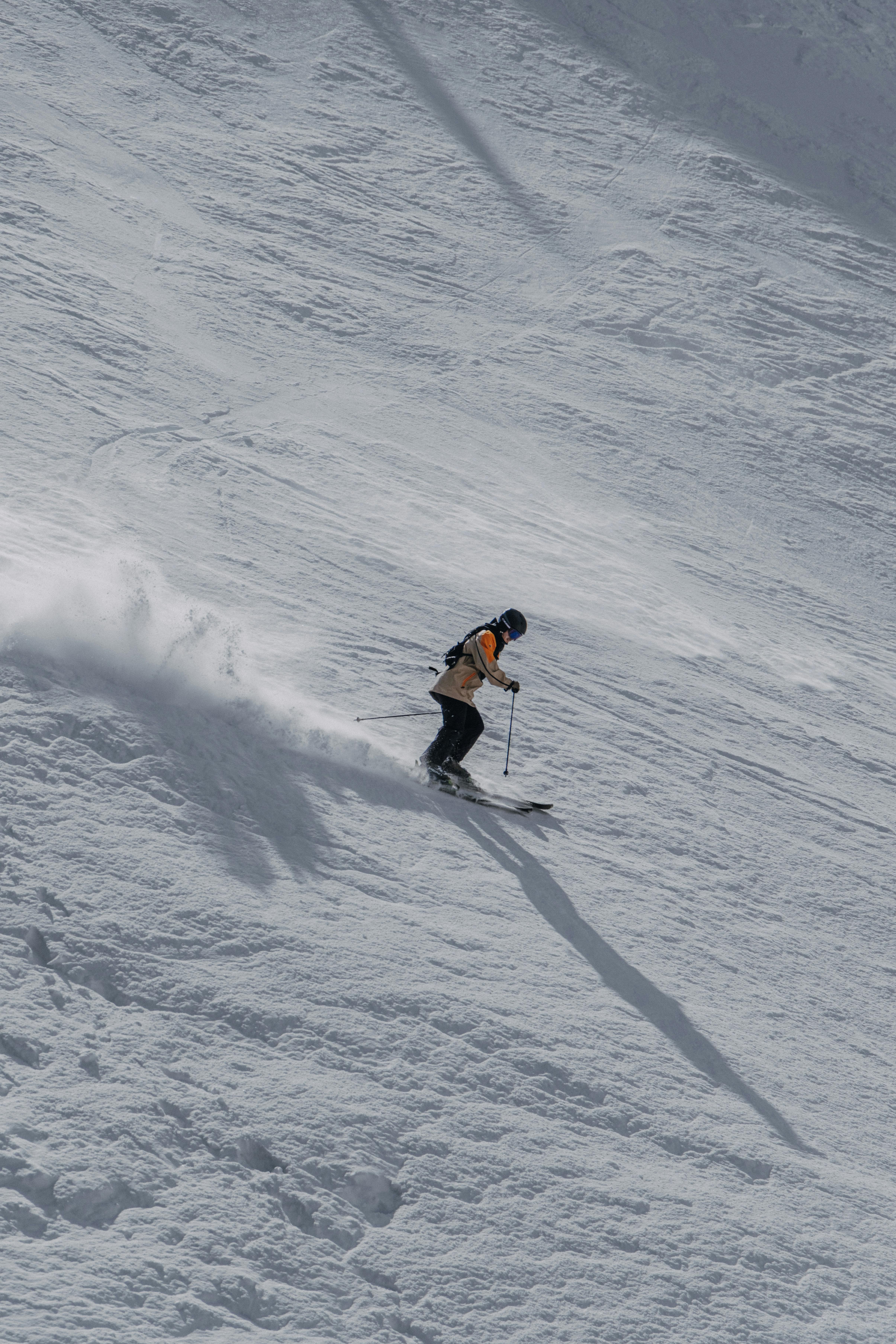 Skier Descending Snowy Mountain Slope