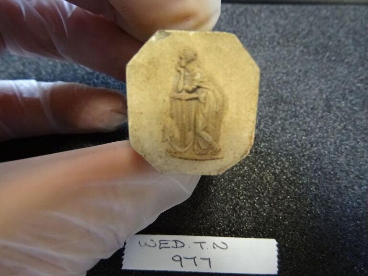 Octagonal Carved Artifact Held by Gloved Hand