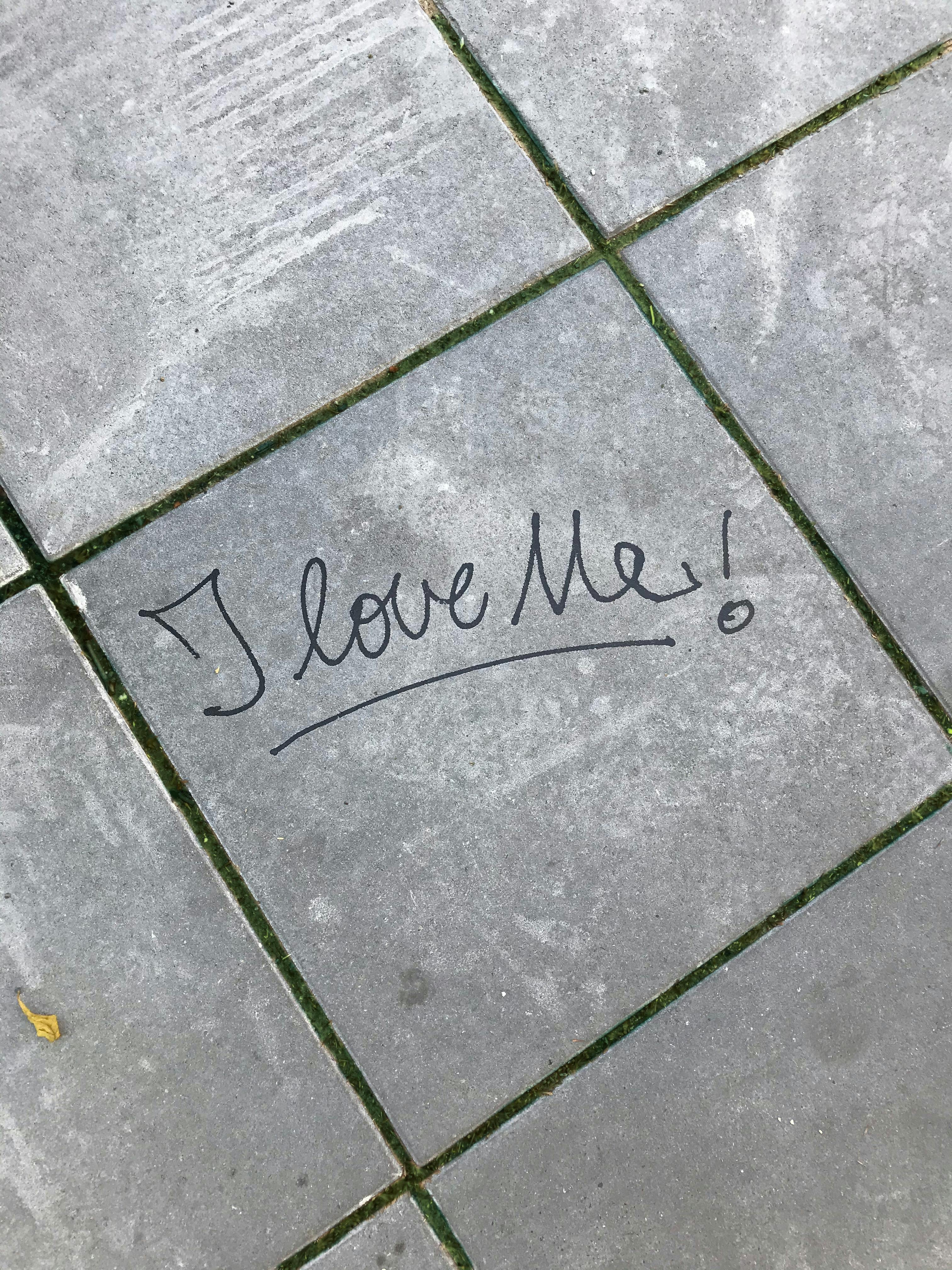 Handwritten 'I love Me!' on Sidewalk Tile