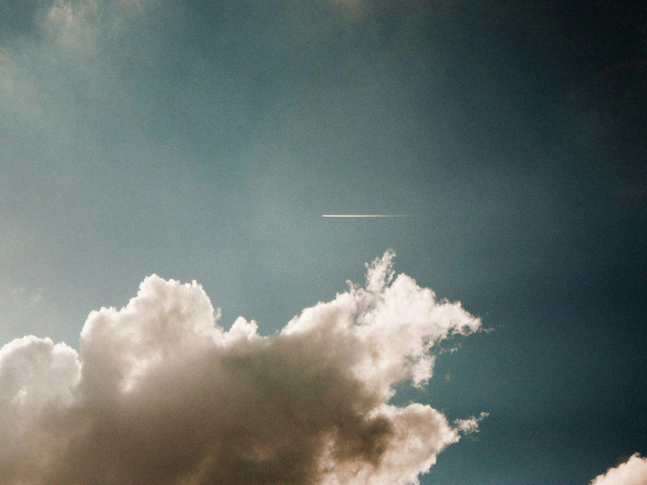 Contrail Over Cloudy Blue Sky