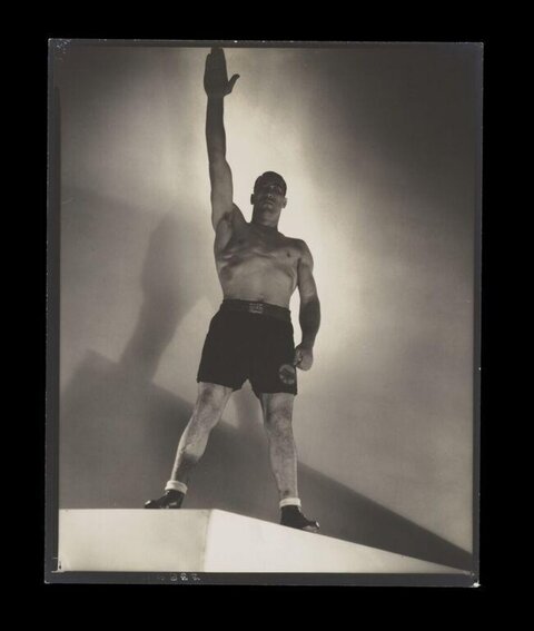 Boxer Raising Arm in Studio Portrait