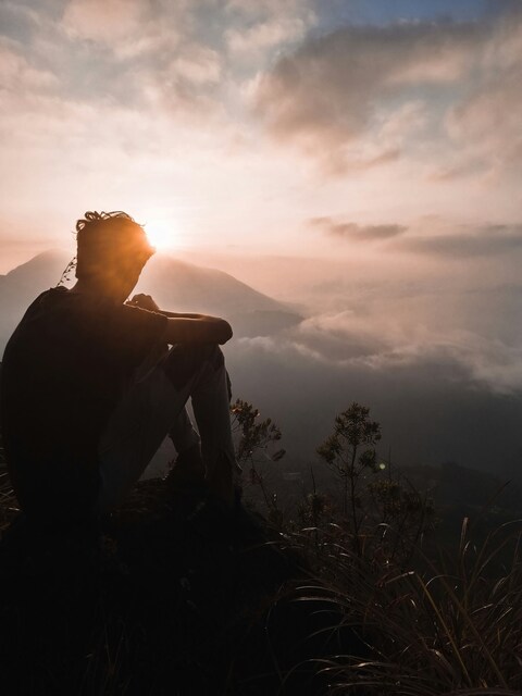 Man Watching Sunrise on Mountain Peak