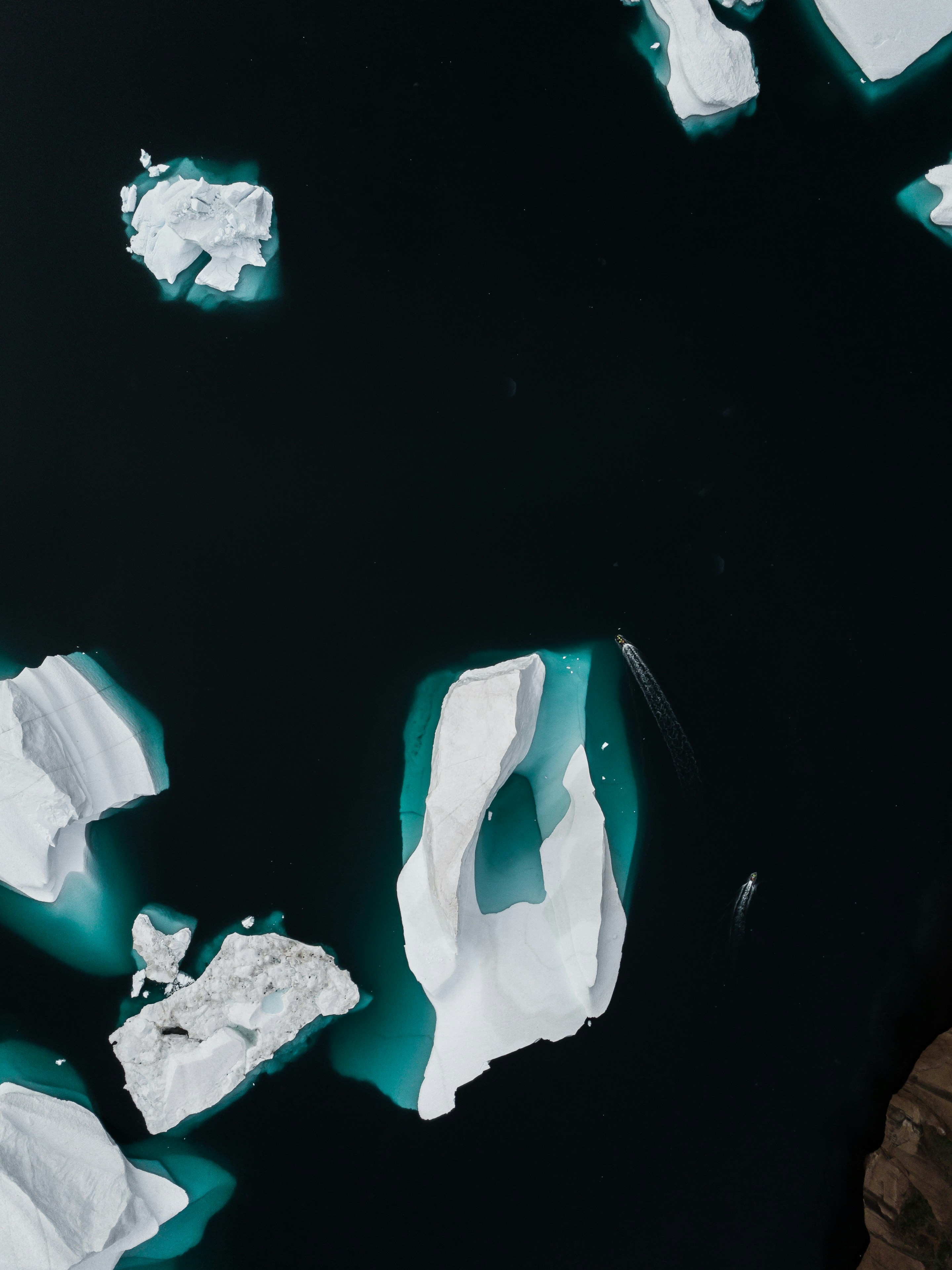 Aerial View of Icebergs in Dark Ocean