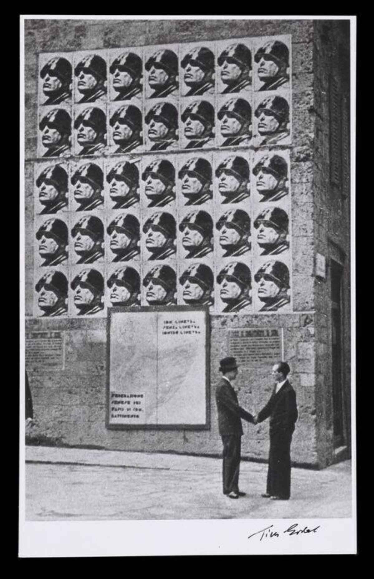 Two Men Shake Hands By Military Propaganda Posters