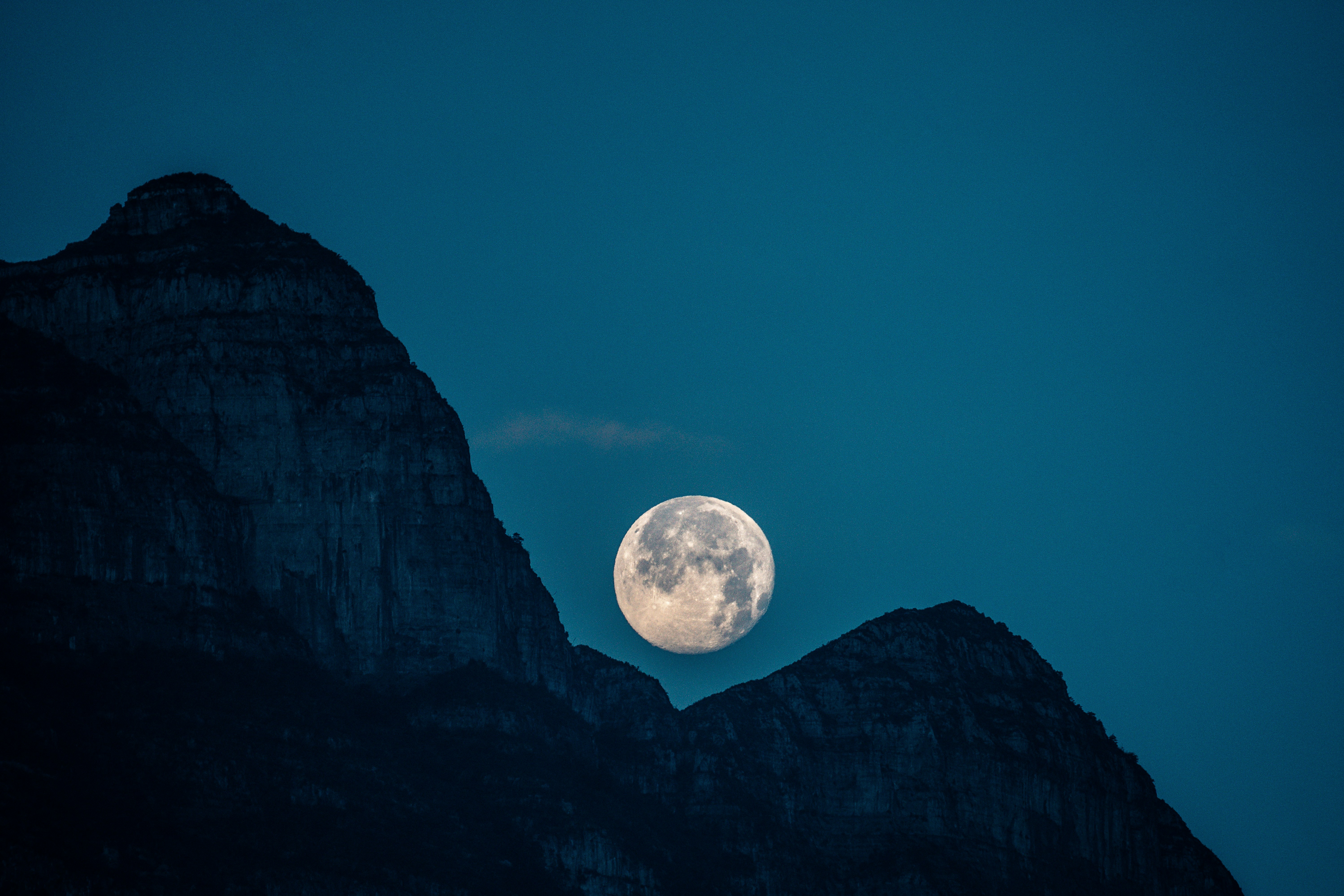 Full Moon Between Mountain Peaks