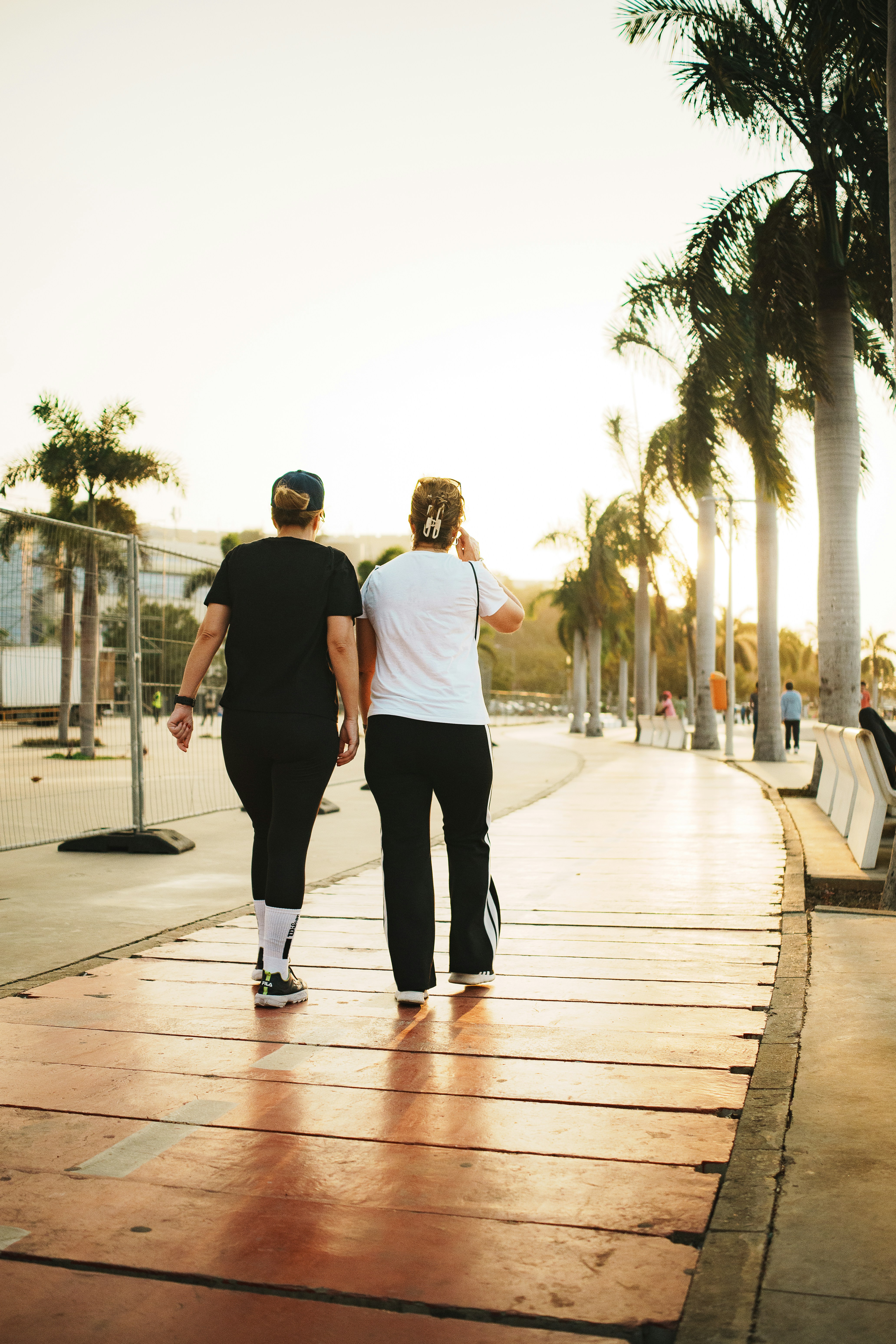 Two Women Walking on Sunset Promenade