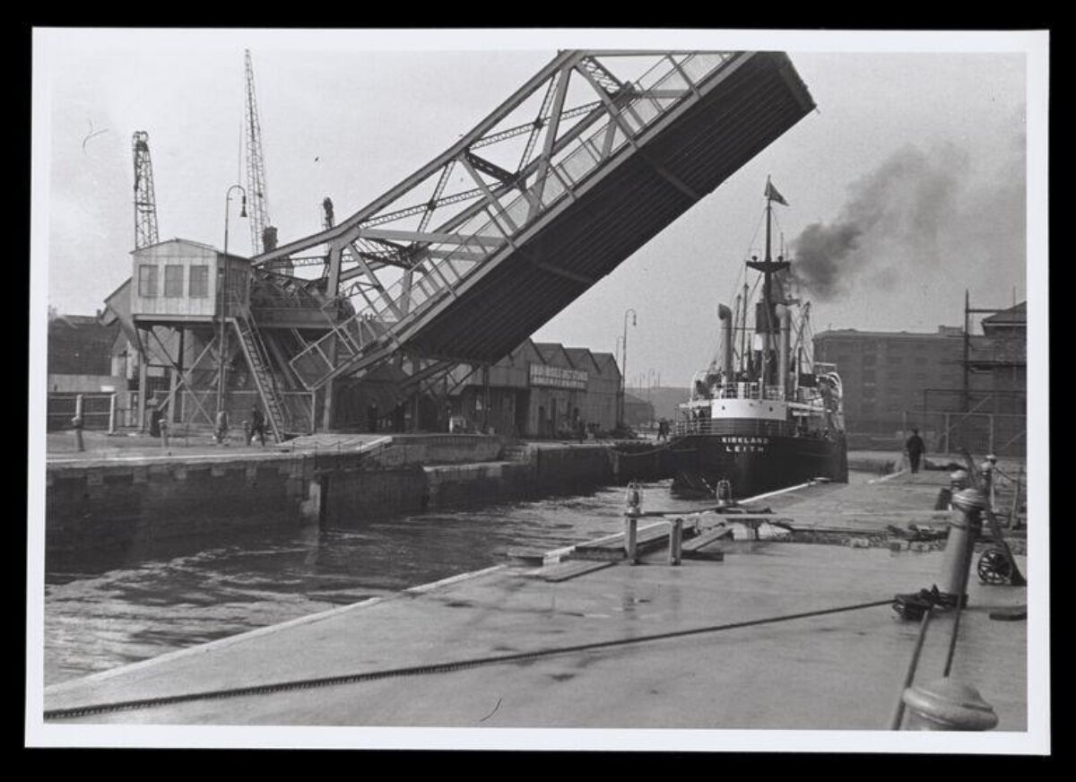Ship Passing Open Lift Bridge at Dock