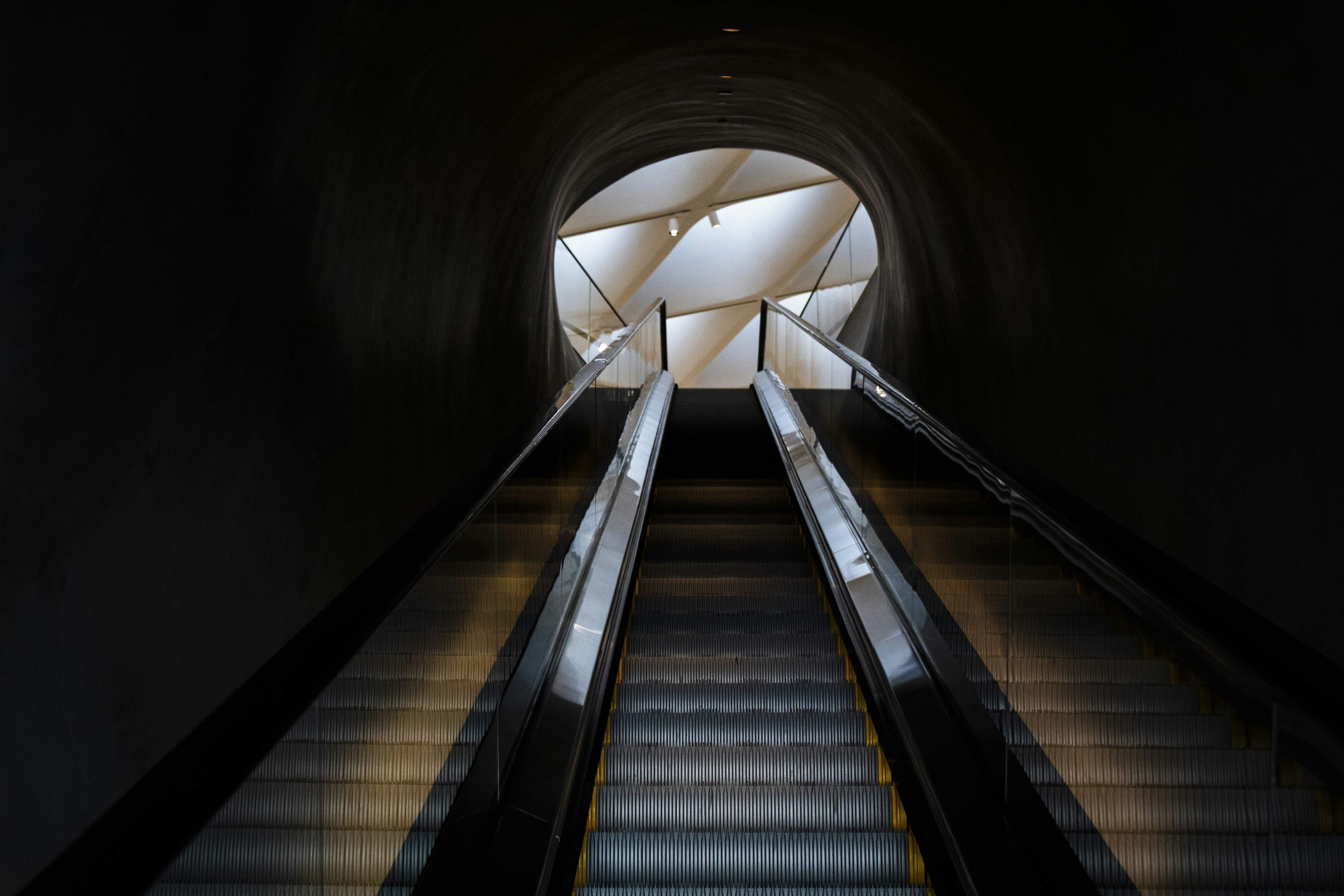 Escalator Leading Up Through Dark Tunnel