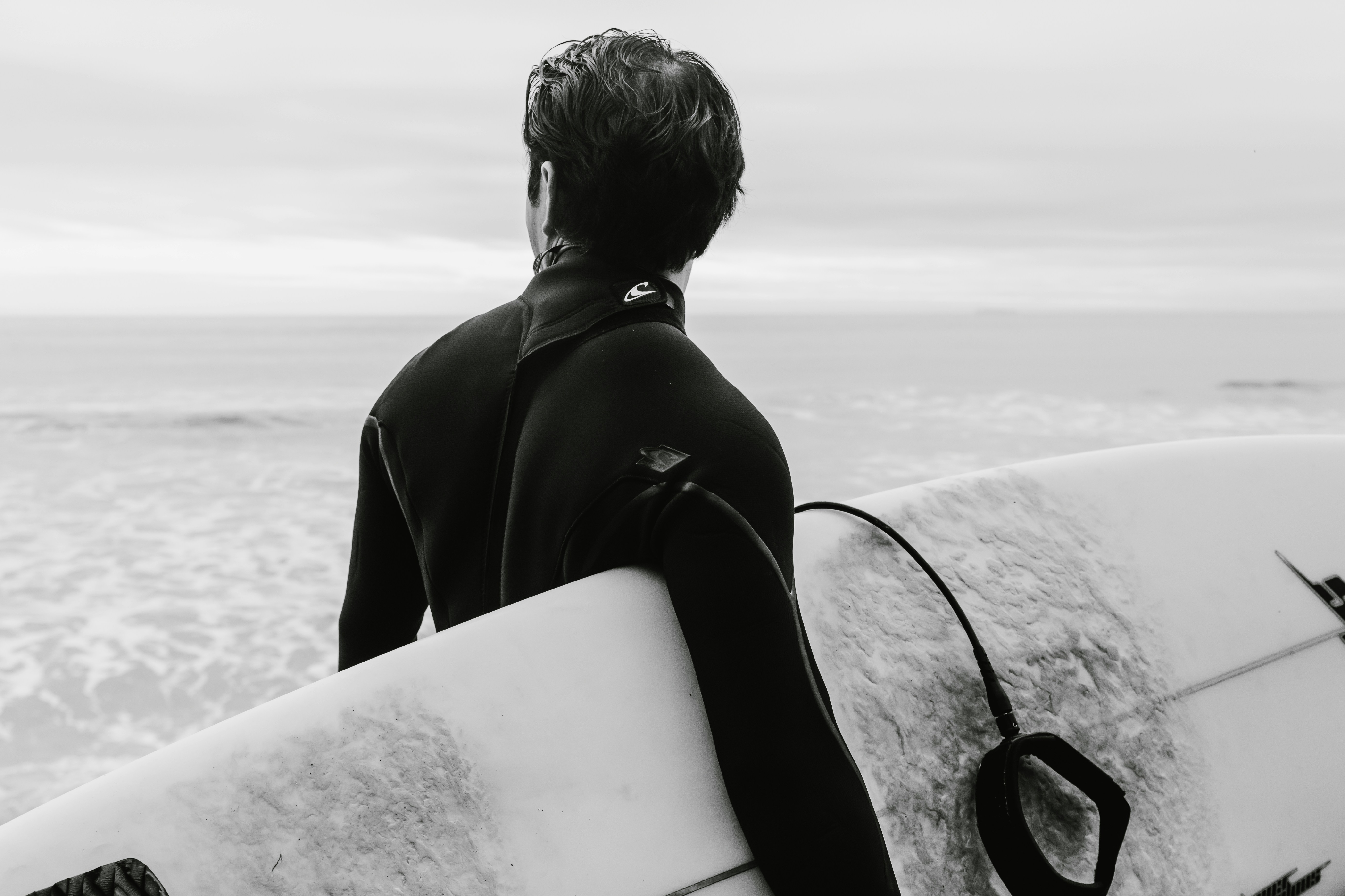 Surfer Facing Ocean With Surfboard